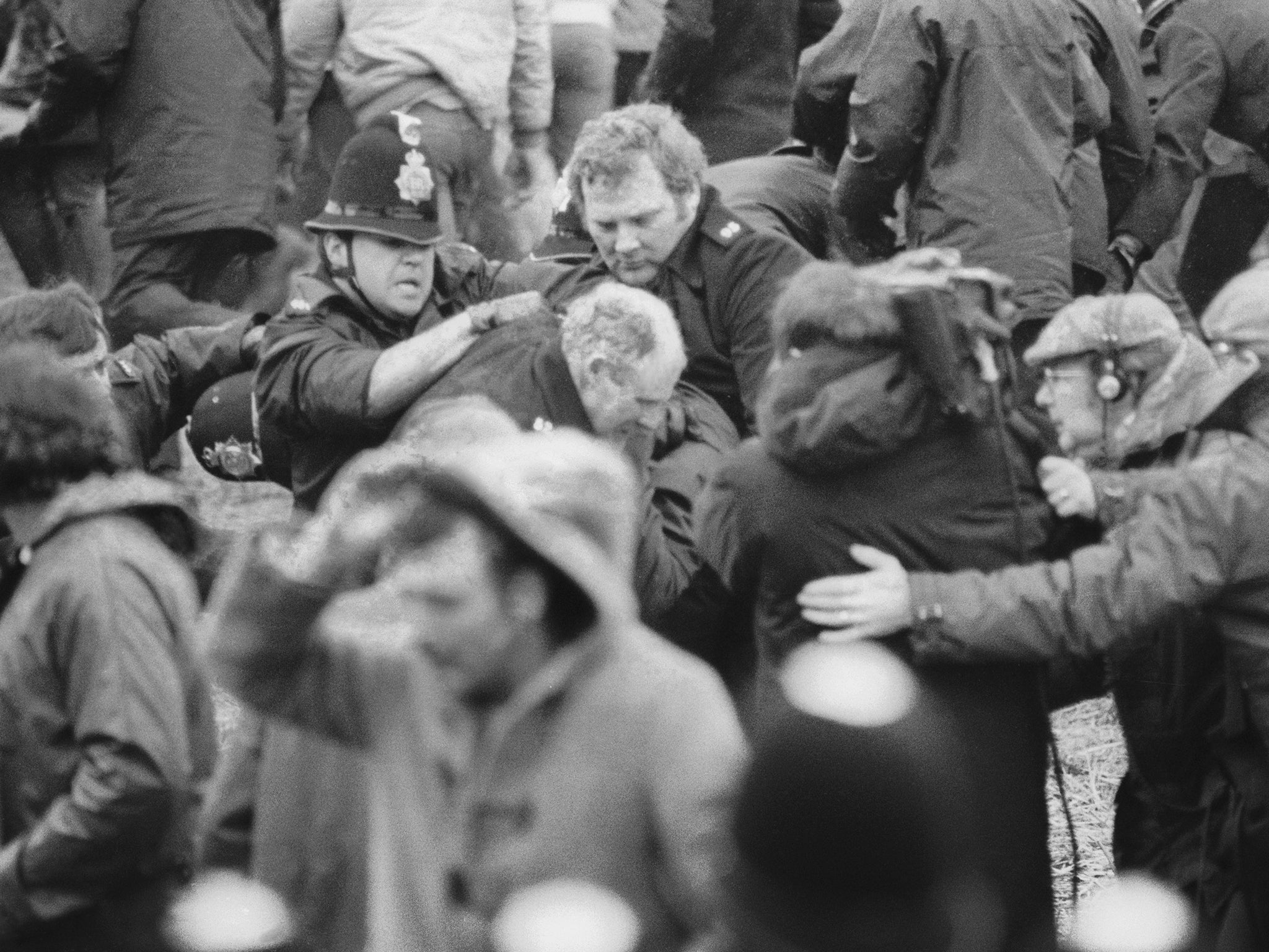 A camera crew films a confrontation between a policeman and a miner