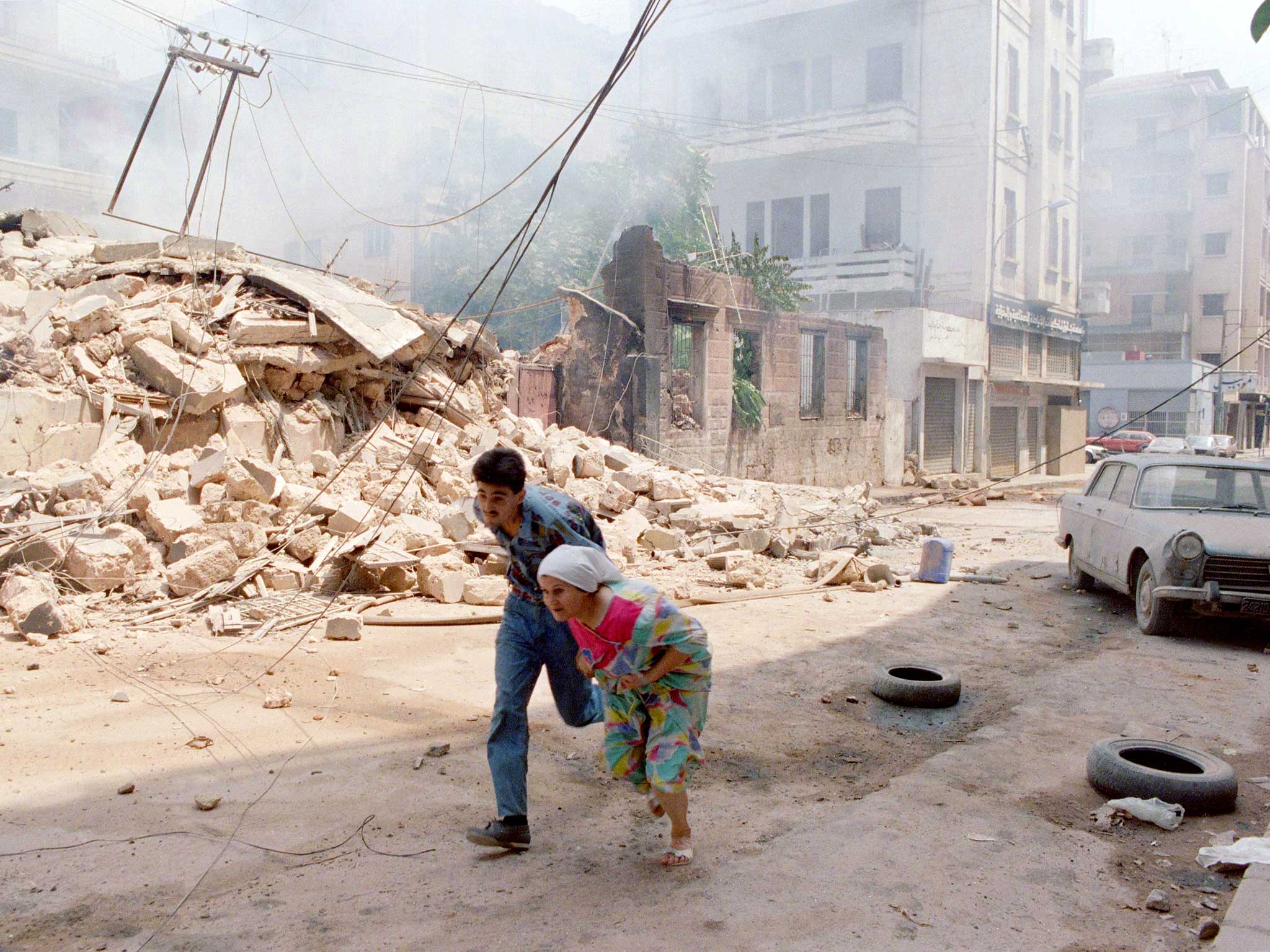 A Lebanese woman and son run through west Beirut under shellfire, August 1989