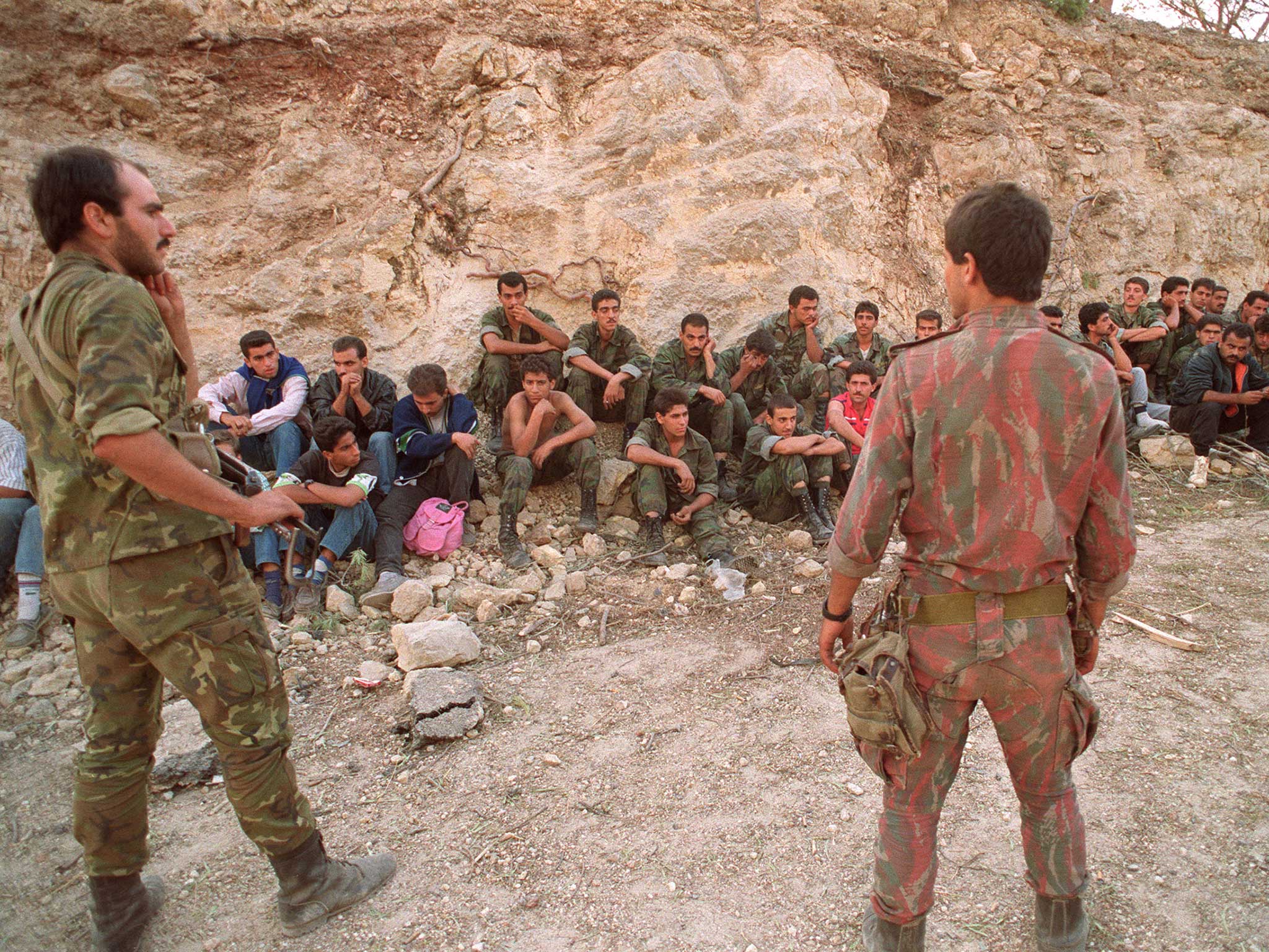 Two Syrian soldiers guard a group of prisoners in Beirut, October 1990