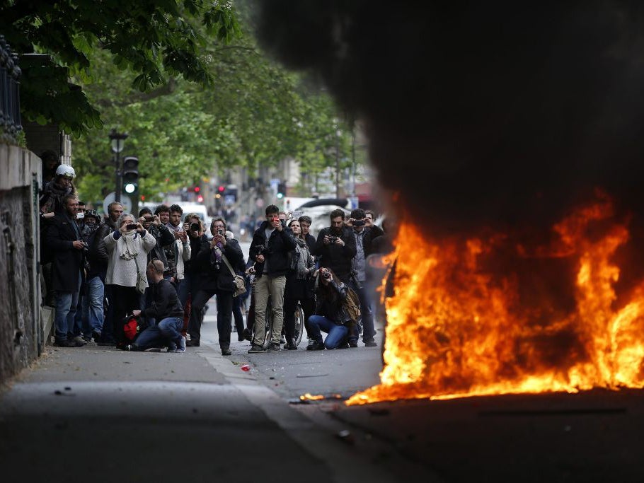 Protesters set a police car on fire during clashes as part as a demonstration, that had been banned, against police violence