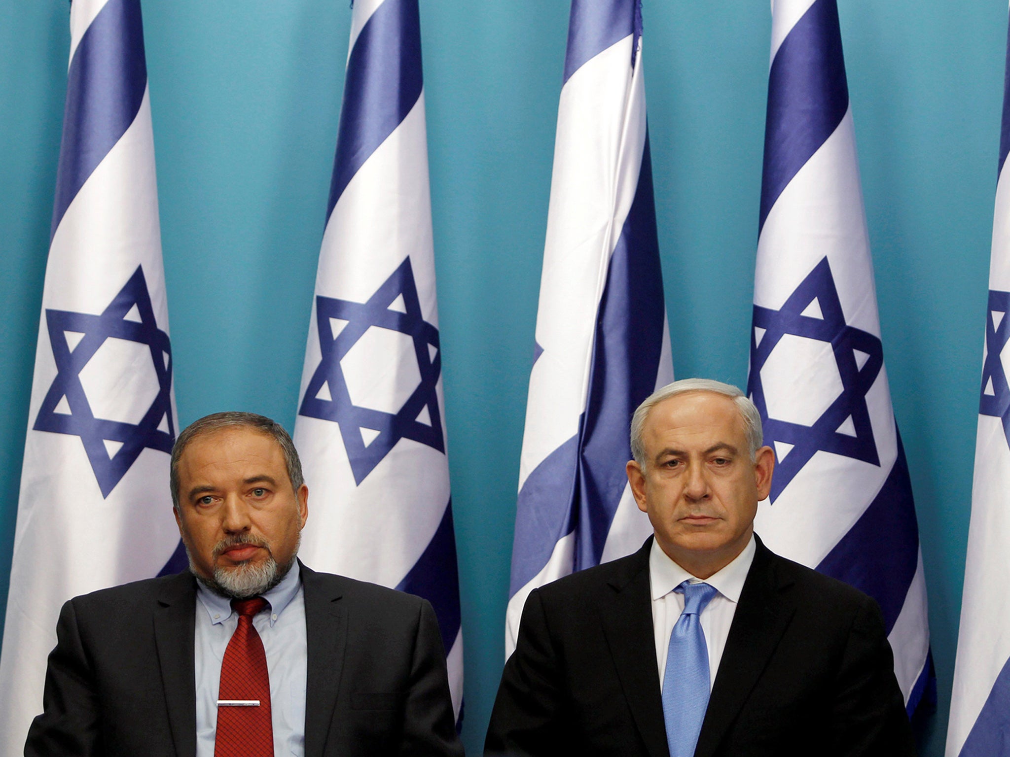 Israel's Prime Minister Benjamin Netanyahu (R) sits next to then Foreign Minister Avigdor Lieberman in 2012