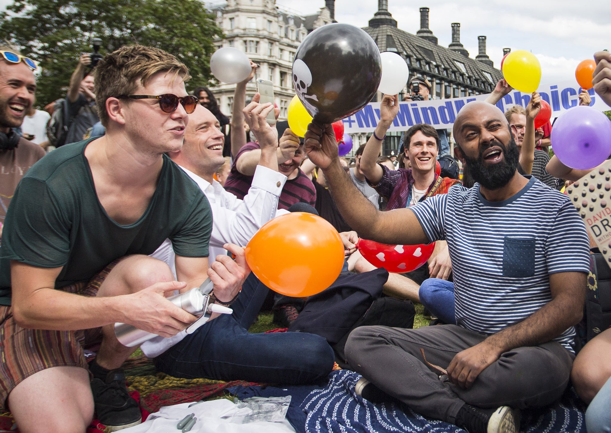 A group of demonstrators chant and inhale nitrous oxide in protest at the Government's proposed ban on legal highs on 1 August 2015