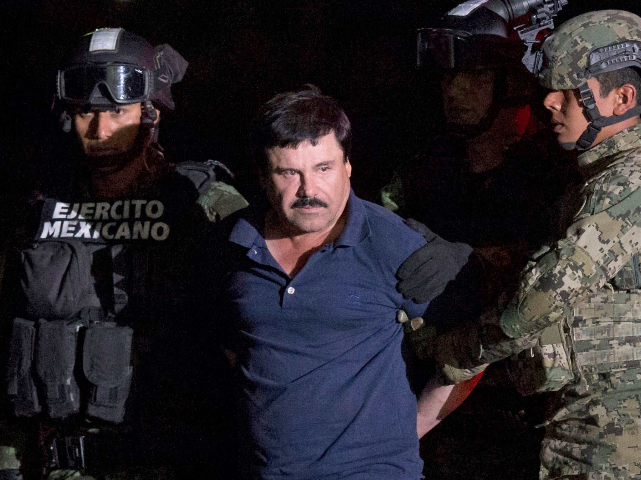 Joaquin ‘El Chapo’ Guzman is made to face the press as he is escorted to a helicopter in handcuffs by Mexican soldiers and marines at a federal hangar in Mexico City