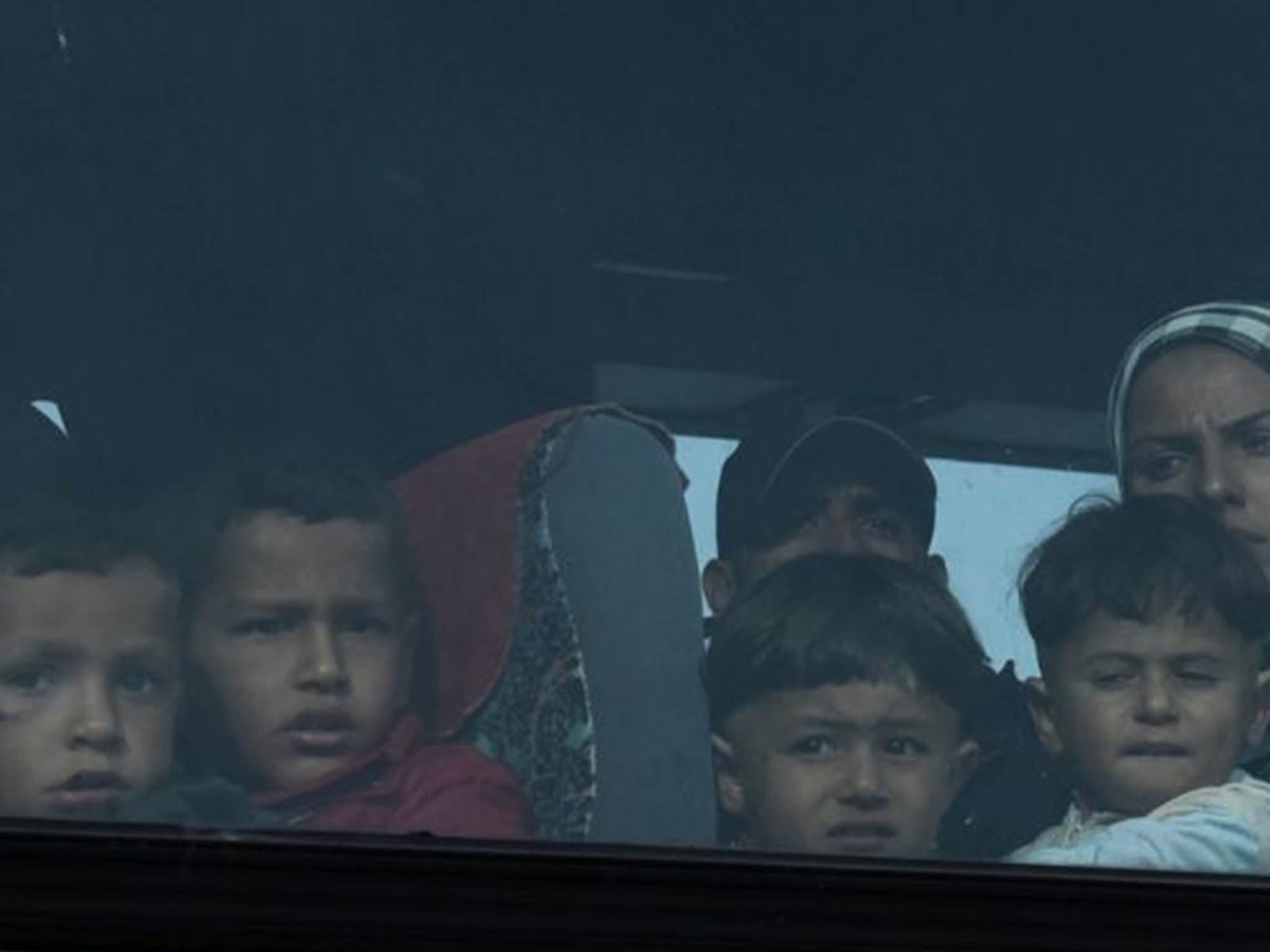 A bus moves a migrant family to an organized camp during an operation to evacuate the makeshift refugee camp at the Greek-Macedonian border