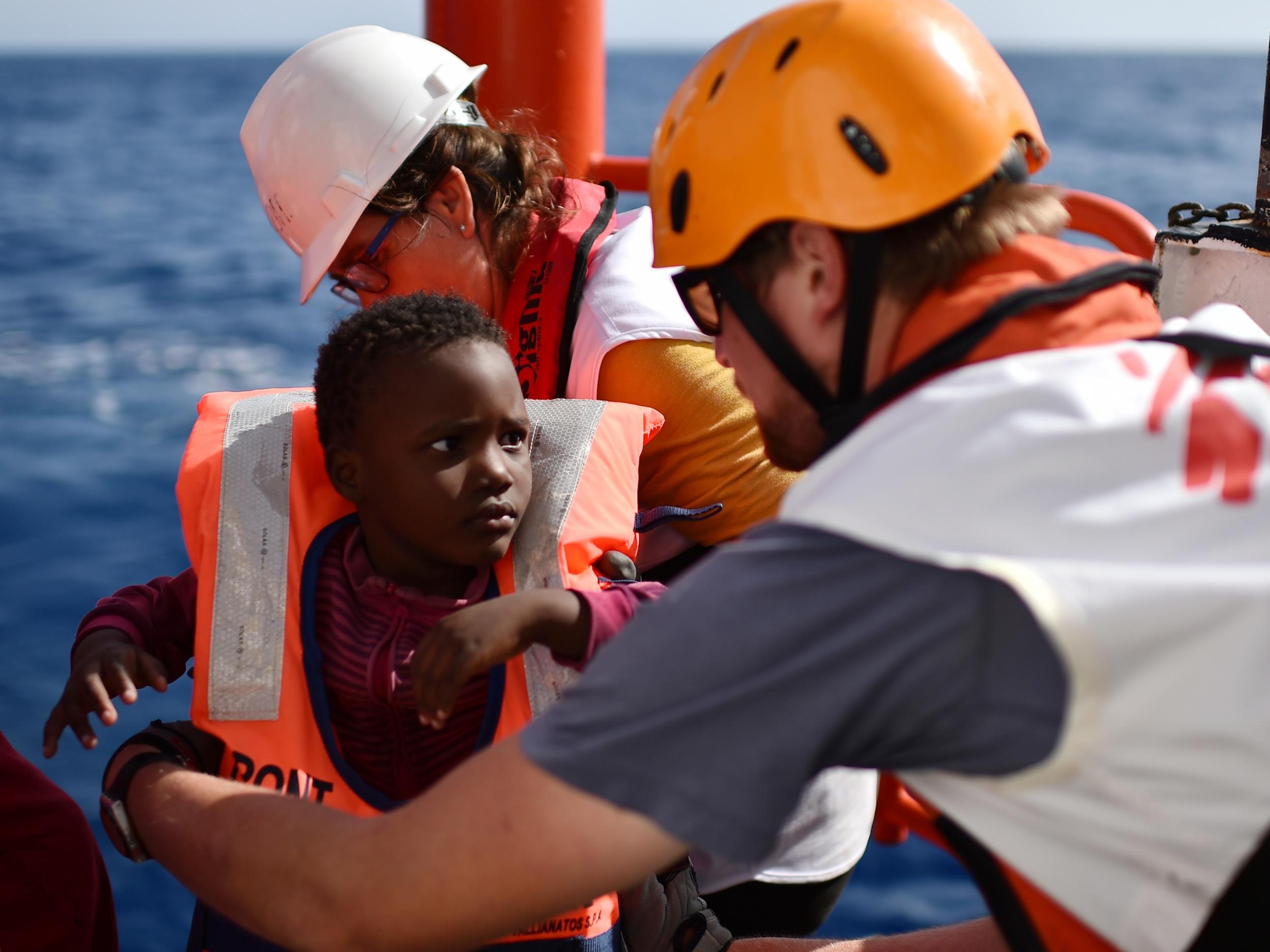 Rescuers take care of a child during a rescue operation at sea of migrants and refugees with the Aquarius, off the Libyan coast