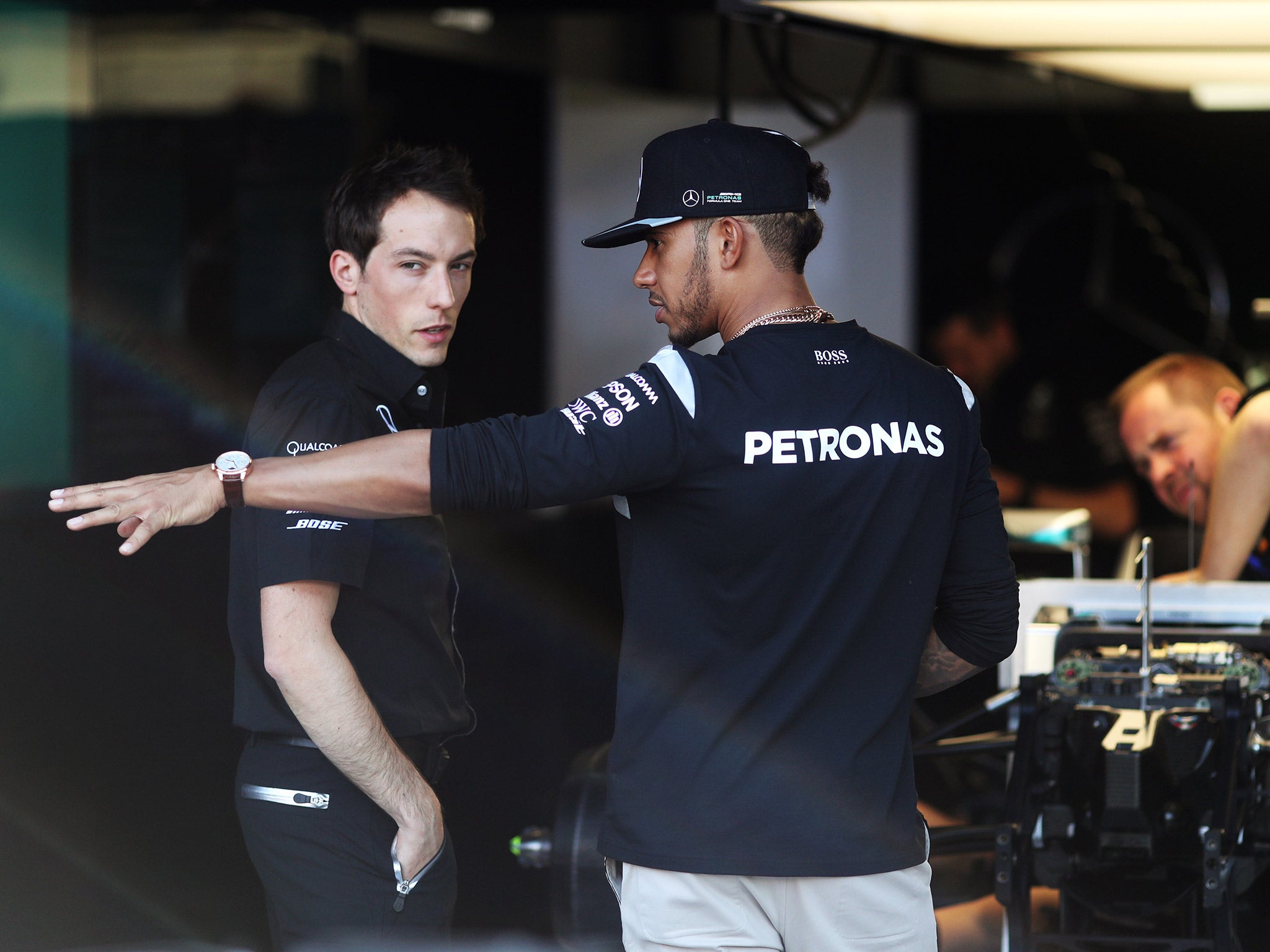 &#13;
amilton speaks with his engineers in the Mercedes pit garage &#13;