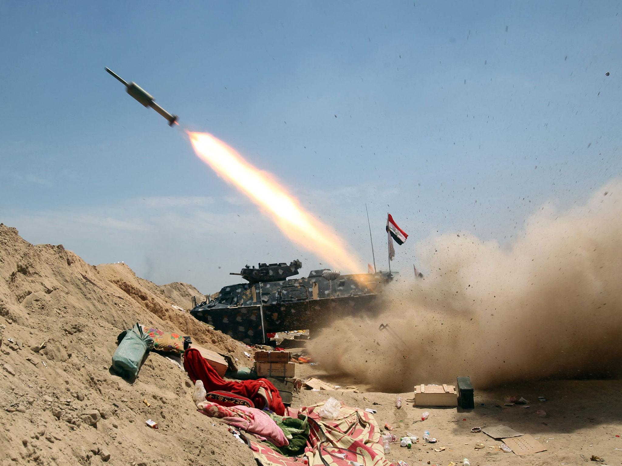 Iraqi government forces fire a rocket north-east of Fallujah