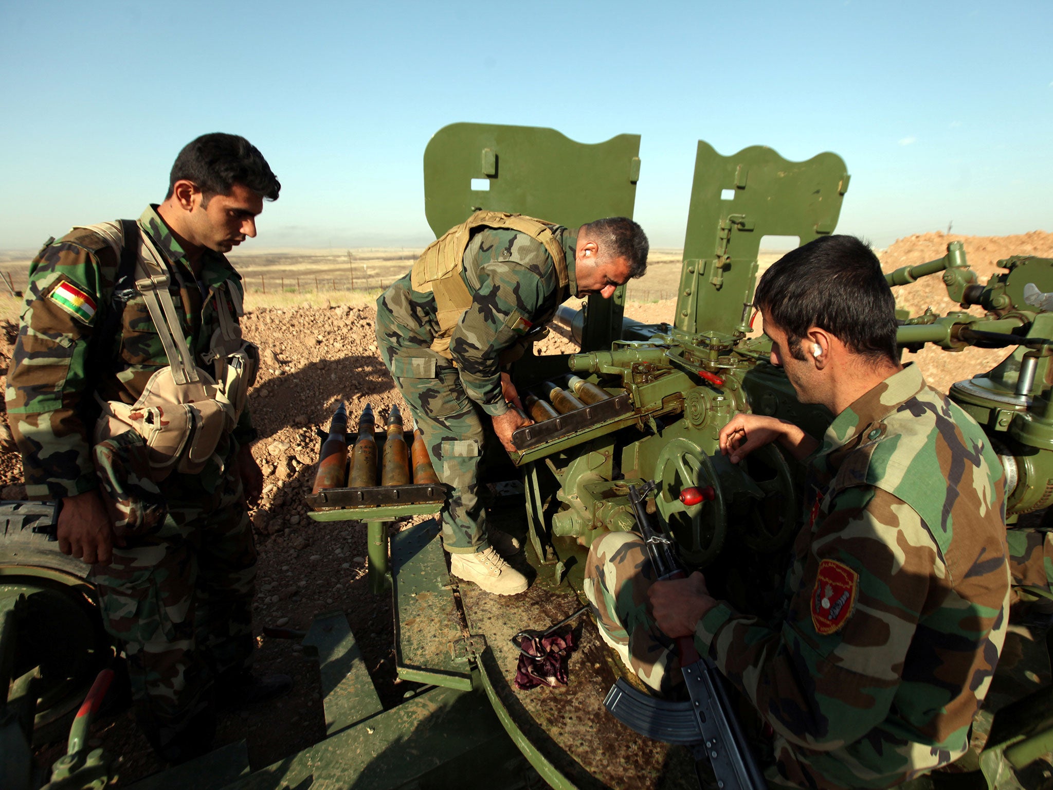 &#13;
Kurdish Peshmerga forces reload a weapon during clashes with Isis militants in a village east of Mosul &#13;