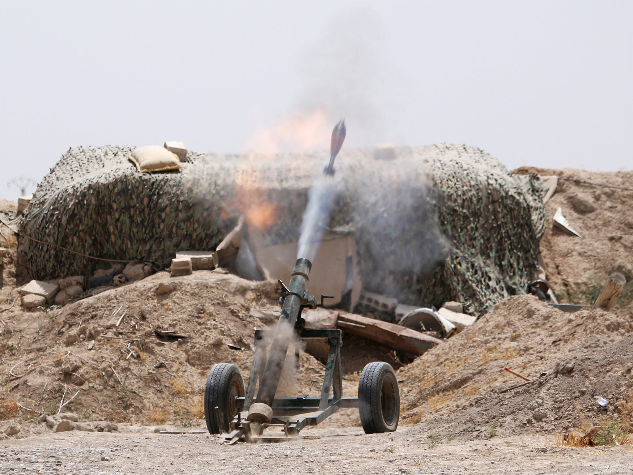 Fighters of the Syria Democratic Forces fire a mortar shell towards positions held by Islamic State fighters in northern province of Raqqa