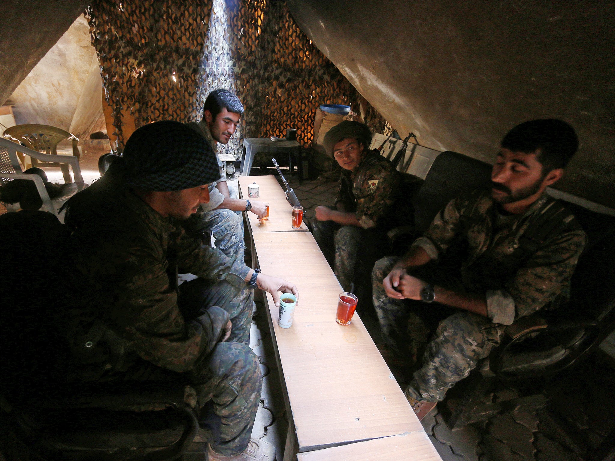 Fighters of the Syria Democratic Forces drink tea as they rest inside a shelter in northern province of Raqqa