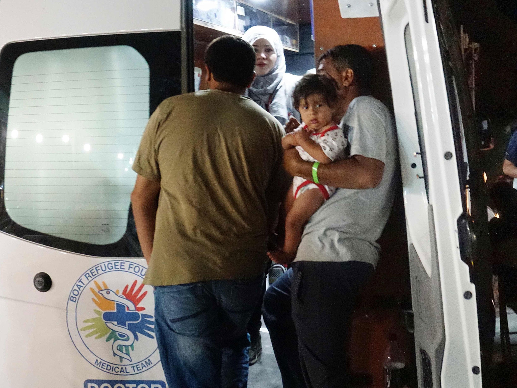 A migrant family receives medical assistance, after overnight clashes at the Moria detention camp on the island of Lesbos