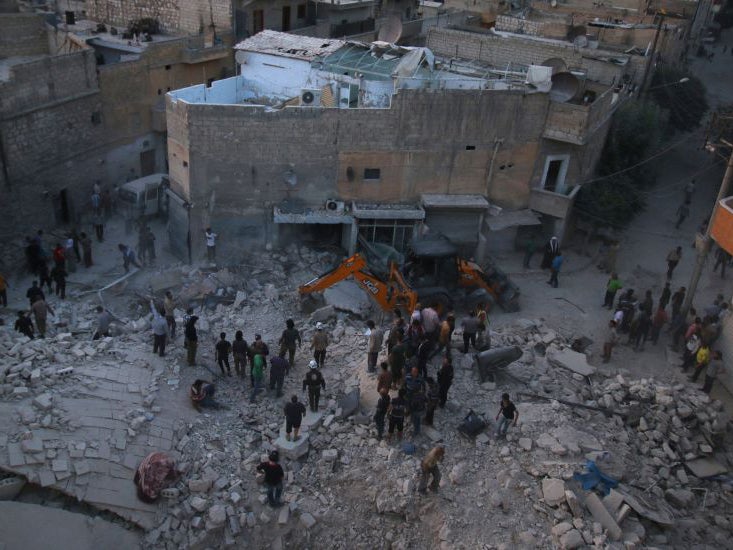 Men inspect damage after an airstrike on Aleppo