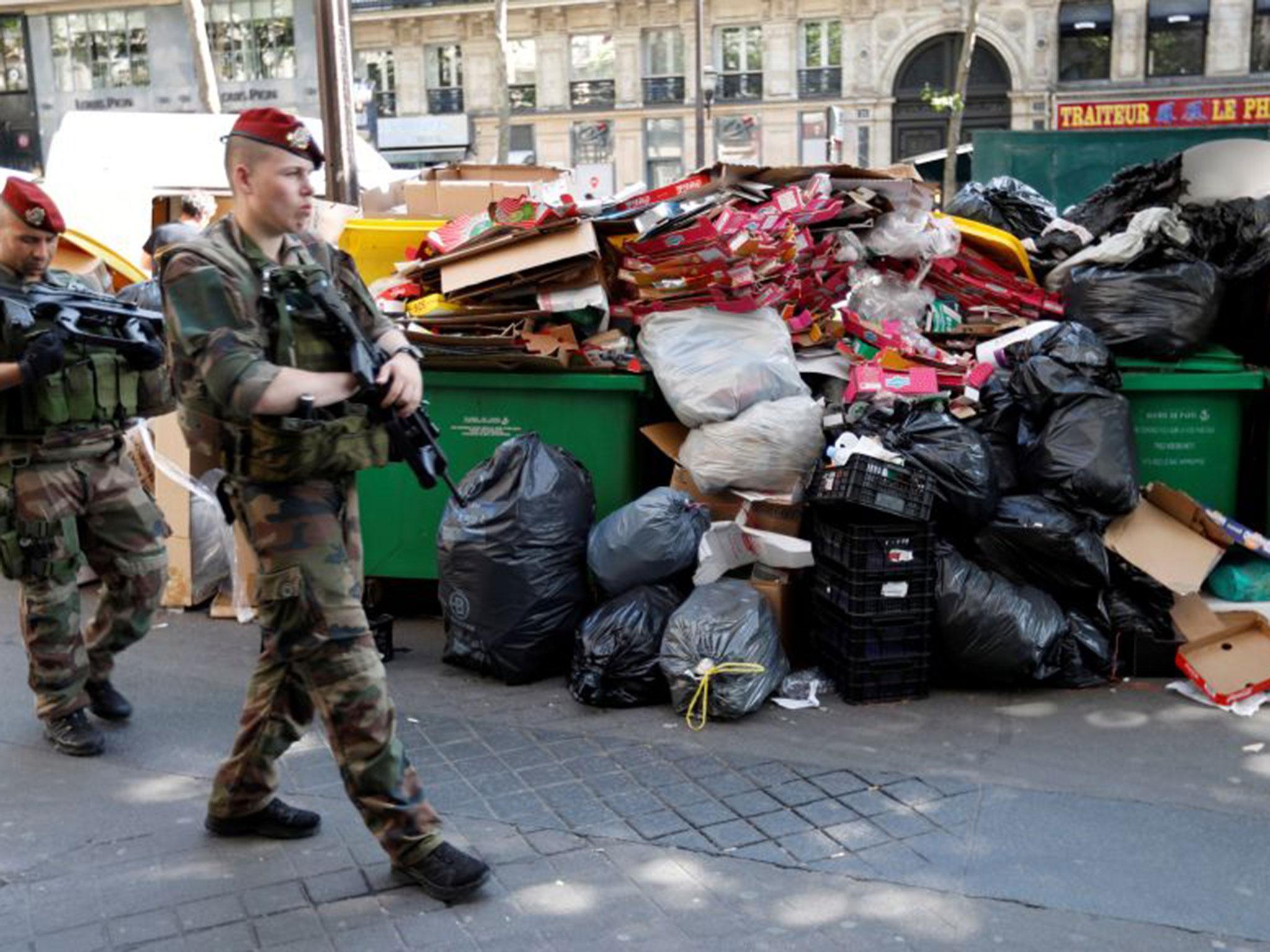 Soldiers pass by a pile of rubbish bags on the Grands Boulevards in Paris, France (REUTERS/Charles Platiau)