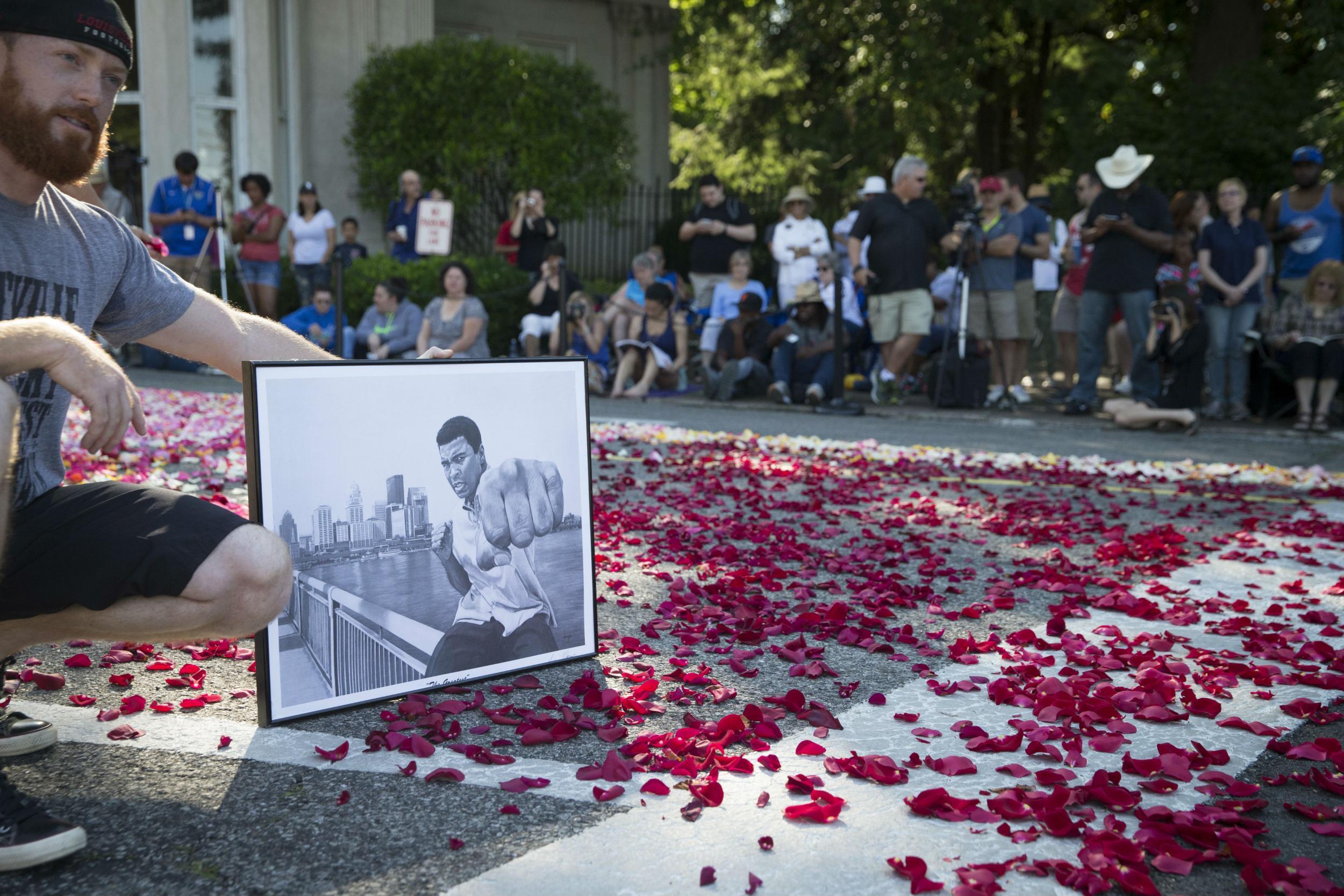 A fan holds a drawing of Muhammad Ali in Kentucky.