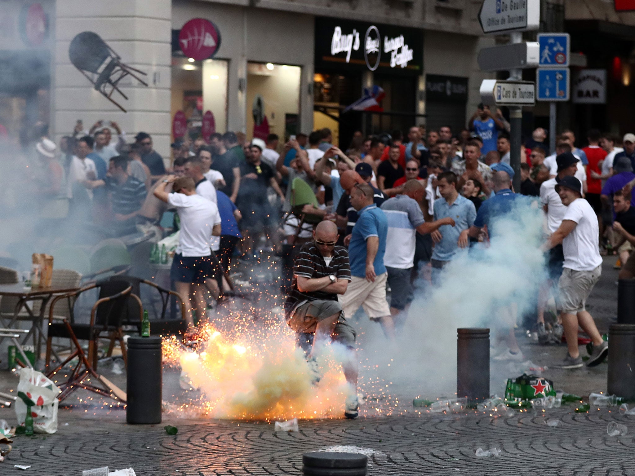 A tear gas canister explodes under a football fan as England fans clash with police in Marseille