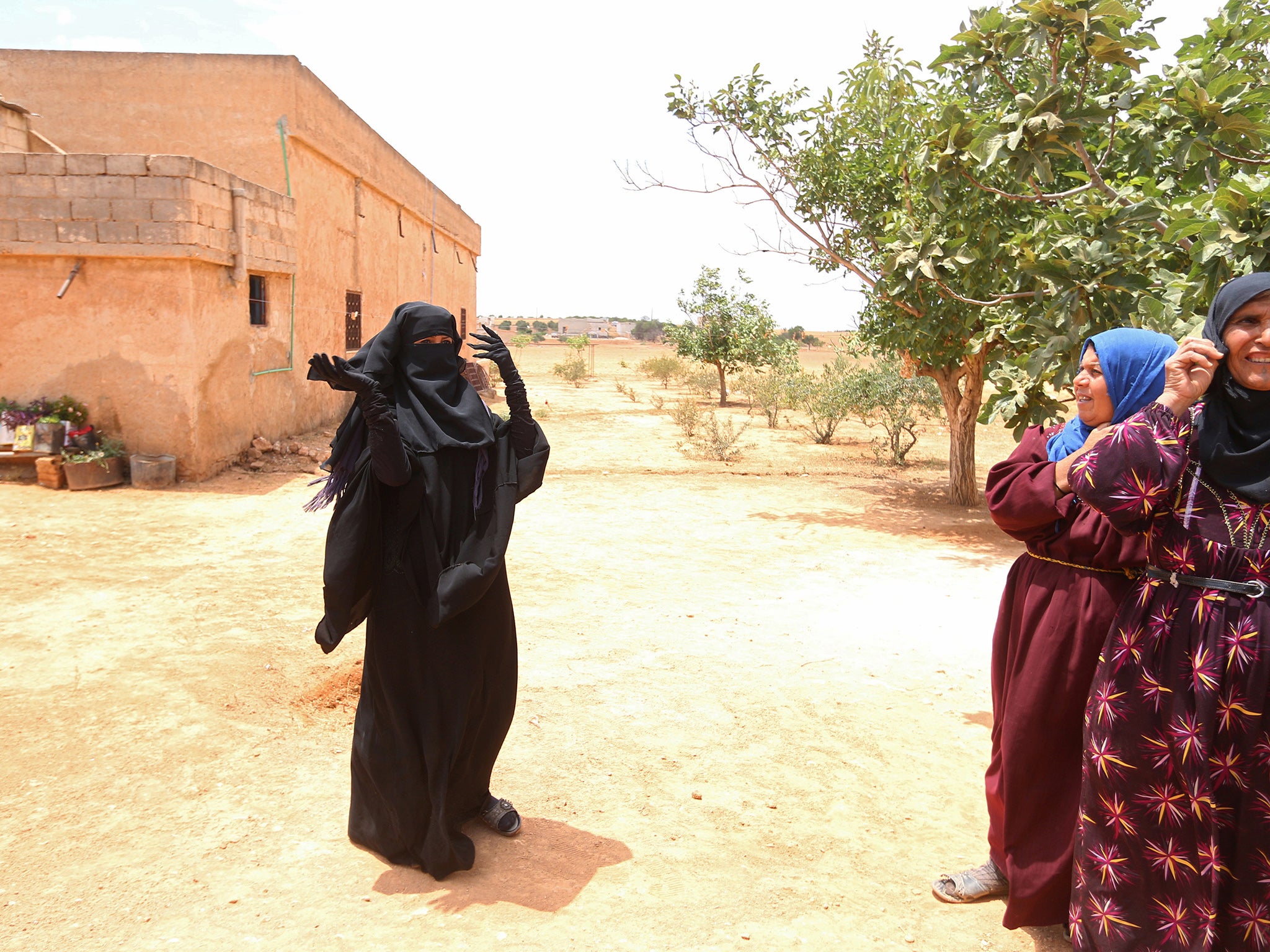 A woman in a Niqab stands in her village after Syria Democratic Forces (SDF) took control of it on Friday