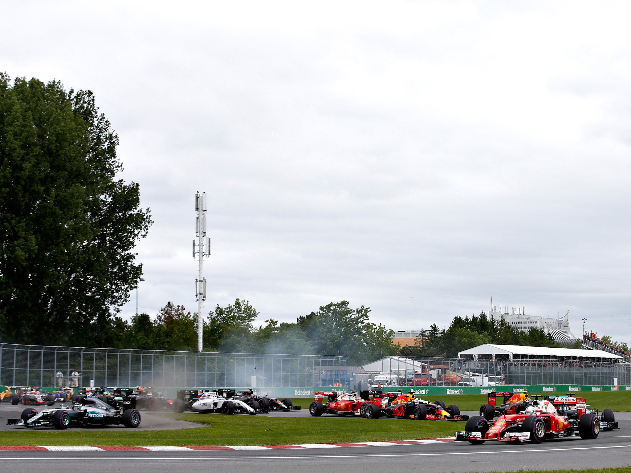 Vettel leads the field into turn one as Rosberg cuts the first corner