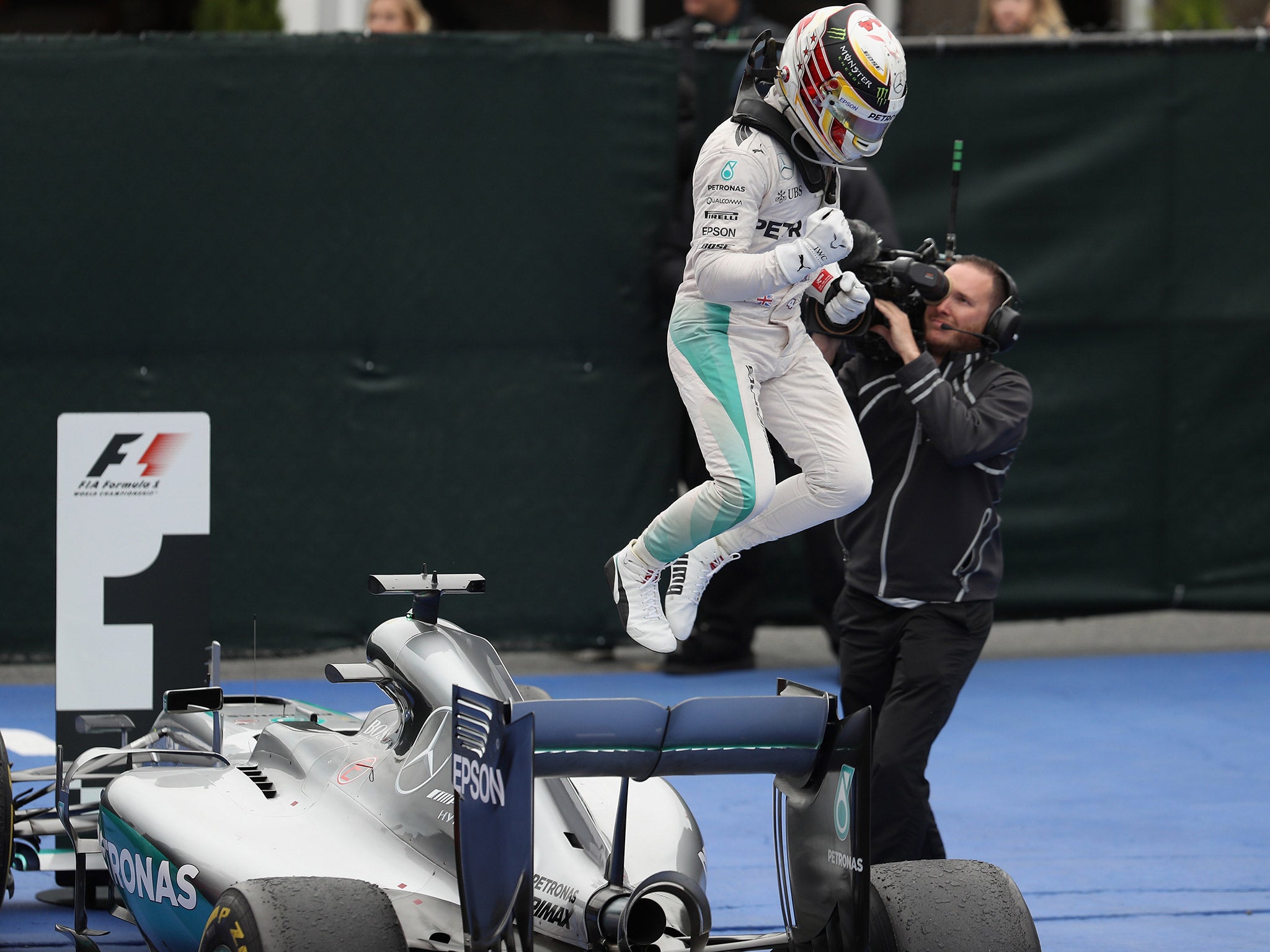 Lewis Hamilton leaps off his Mercedes in celebration after winning in Canada