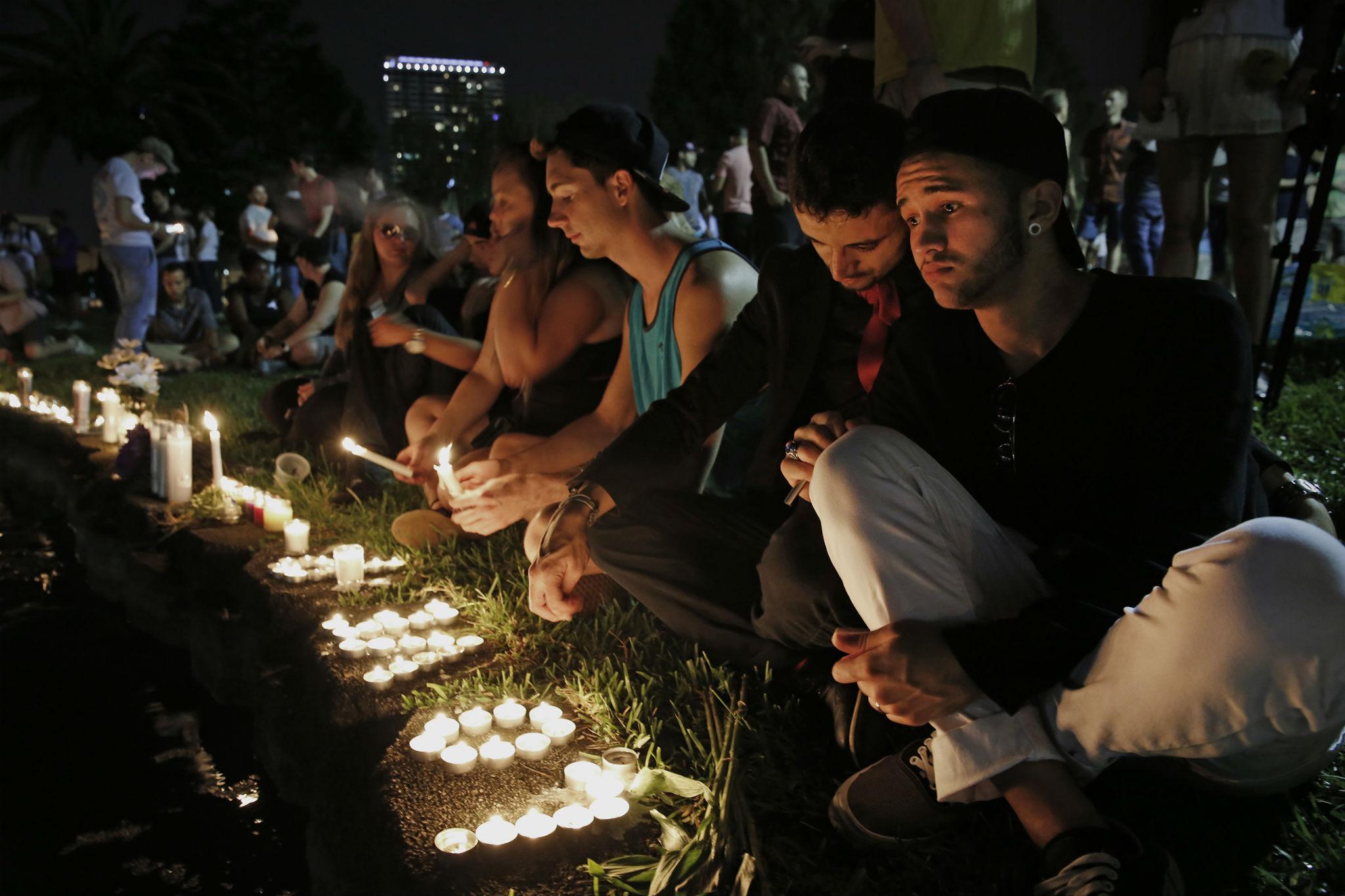 Pulse regulars Johnpaul Vazquez, right, and his boyfriend Yazan Sale, mourn the dead at a vigil in downtown Orlando on Sunday