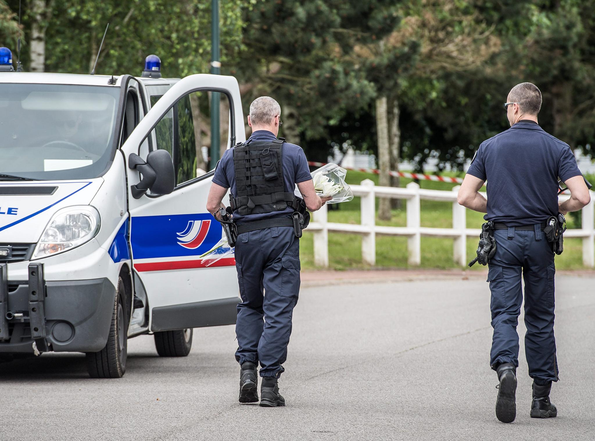 Armed police officers at a security perimeter near the house where the double murder and hostage situation took place