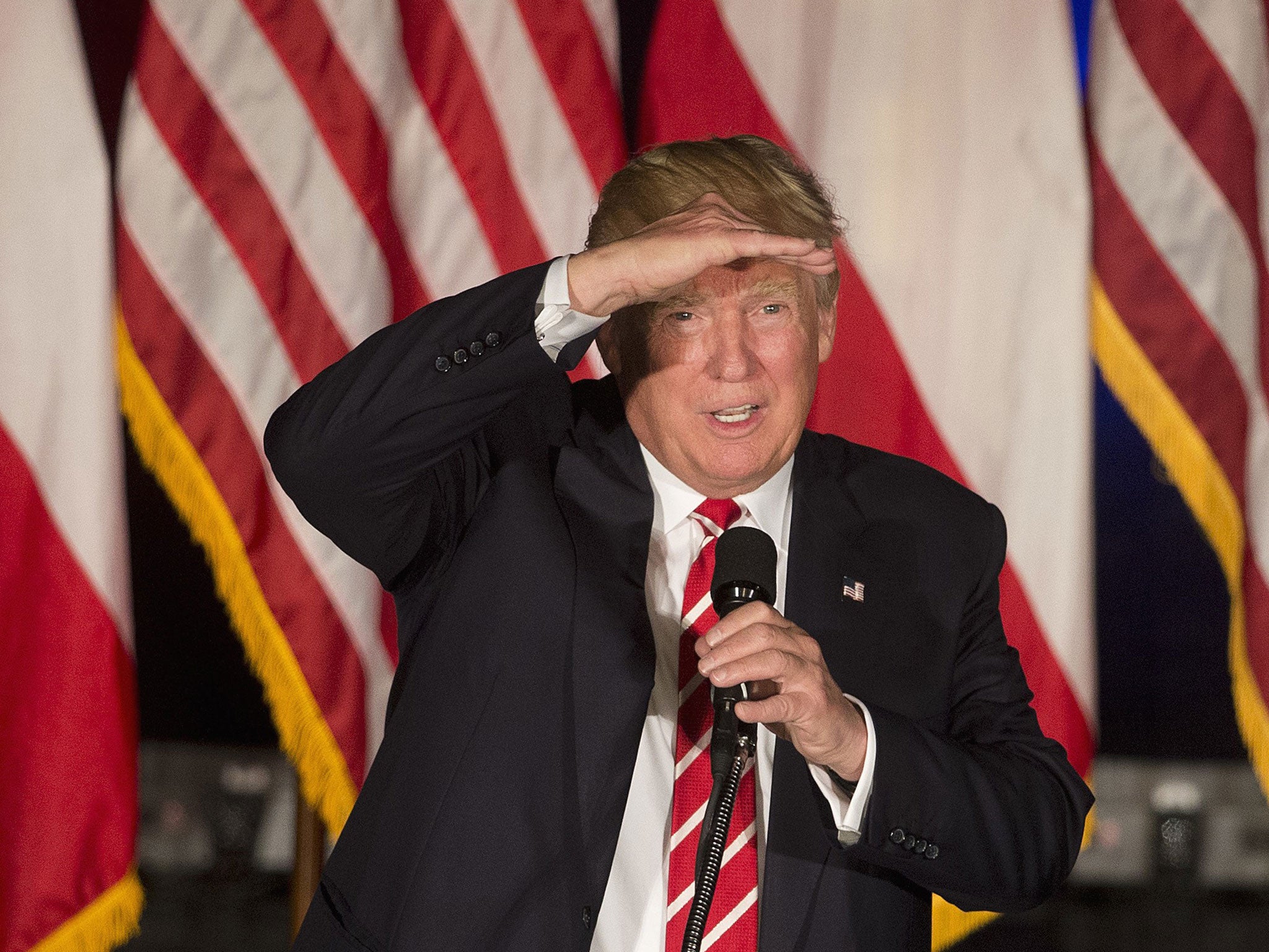 Republican presidential candidate Donald Trump shields his eyes as he speaks during a rally at the Fox Theater, Wednesday, June 15, 2016, in Atlanta