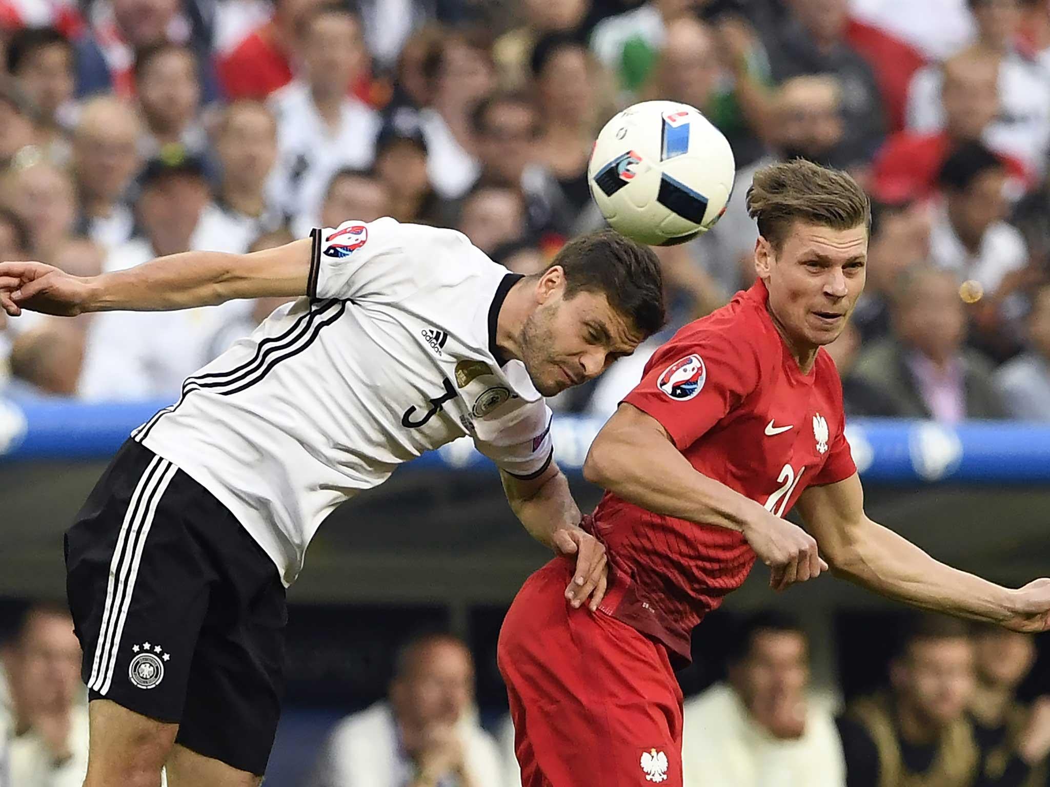 Jonas Hector vies for the header with Lukasz Piszczek