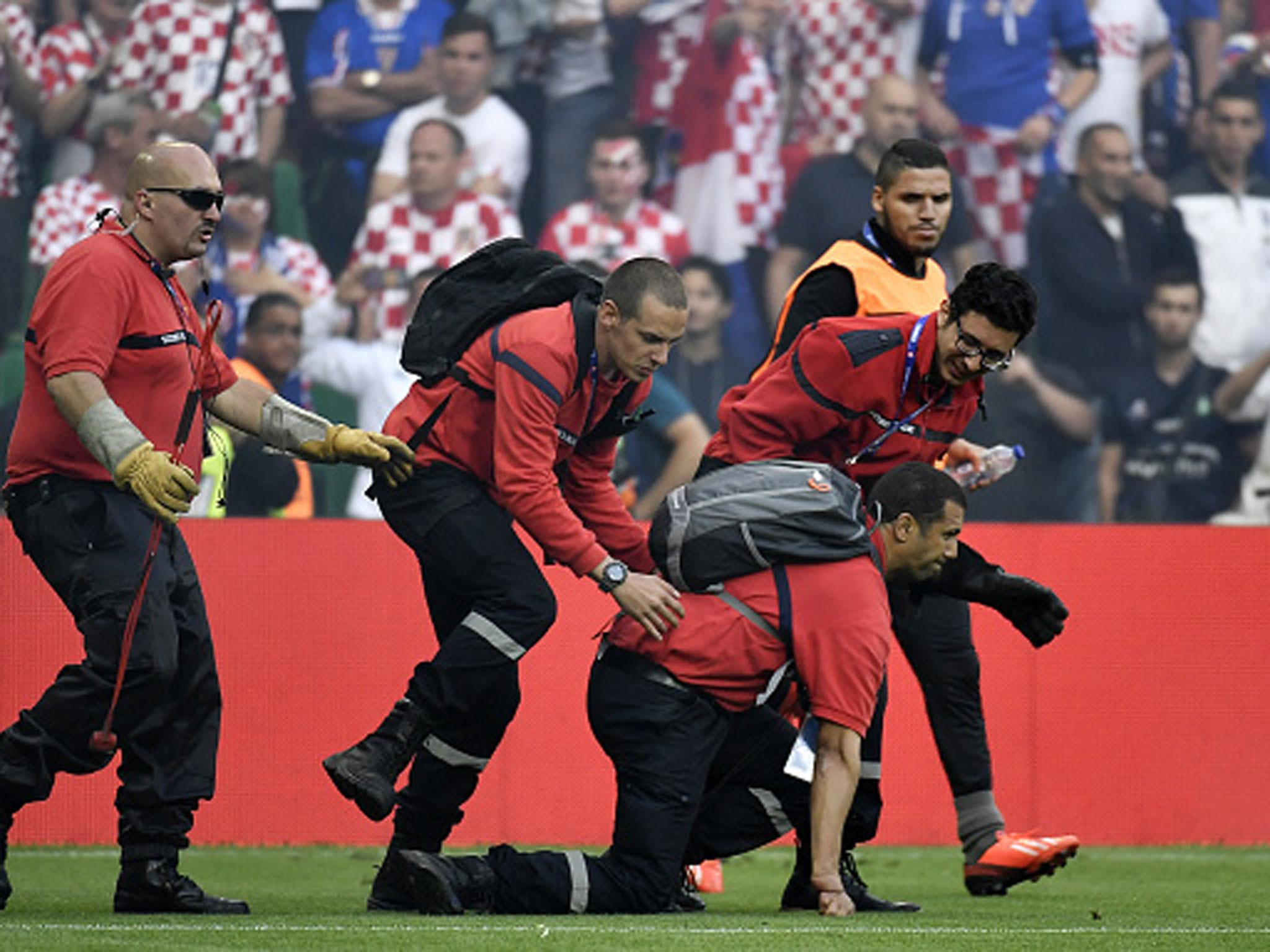 A steward is helped up after being hit by a firecracker in Saint-Etienne (Getty)