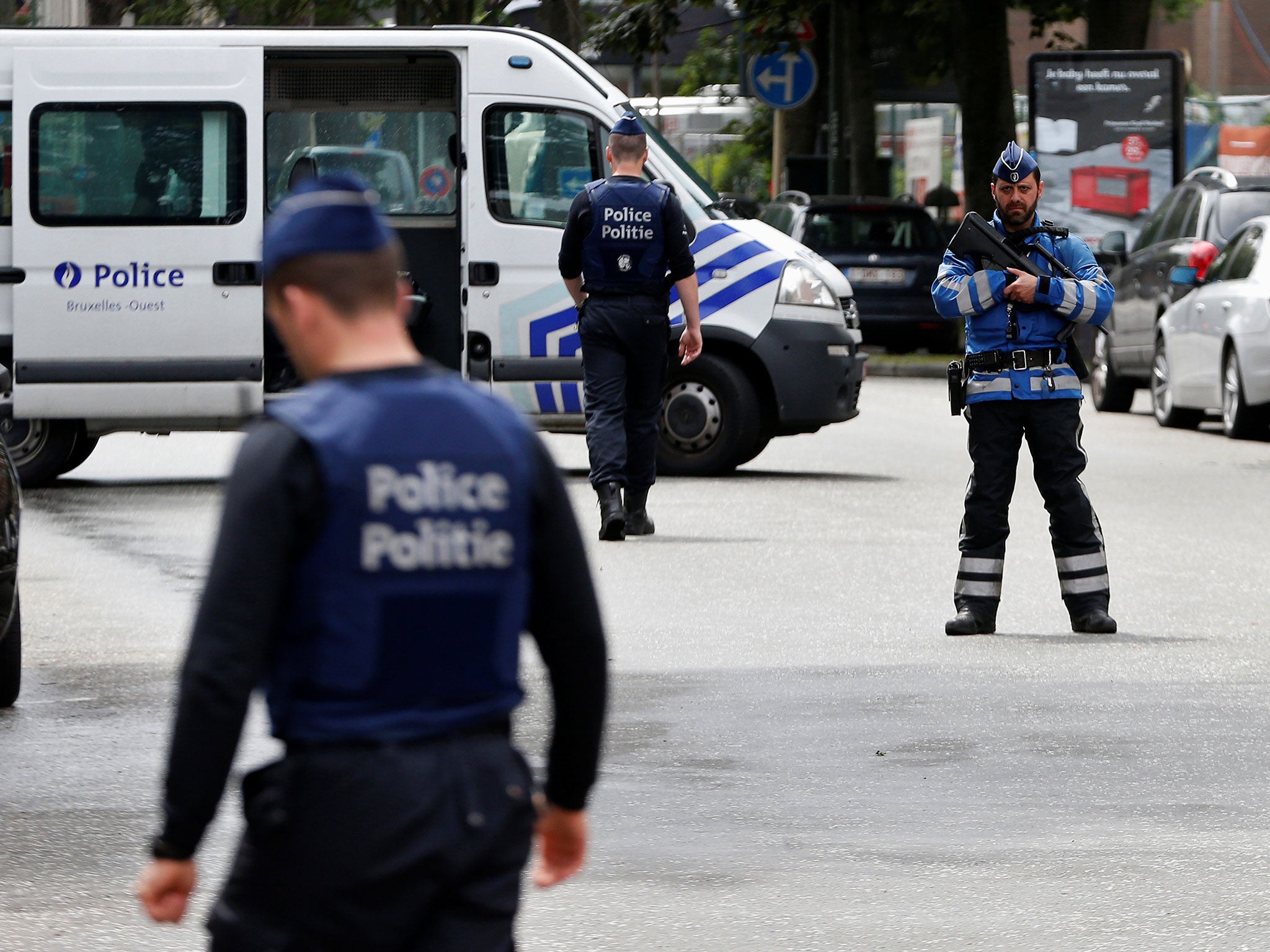 Belgian police officers stand guard near an apartment building during the reconstruction in the Brussels district of Etterbeek on 17 June 2016.