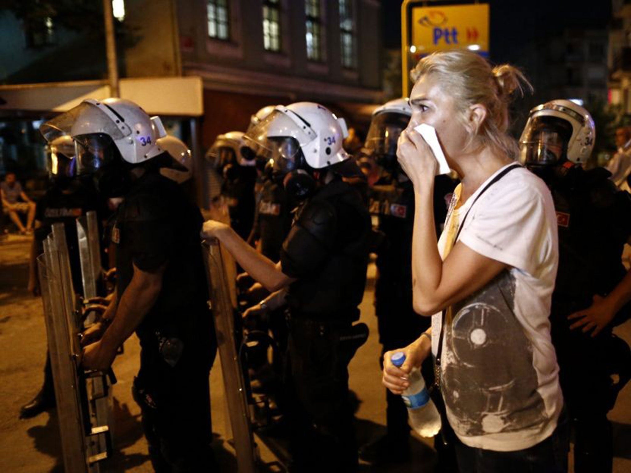 A woman covers her face while protesters clash with Turkish riot police during an anti-government demonstration near Taksim Square, in Istanbul, Turkey, 18 June 2016. An Islamist group reportedly attacked a gathering of people who were listening to Radiohead and drinking alcohol at a record shop in Istanbul on 17 June 2016, according to media reports.