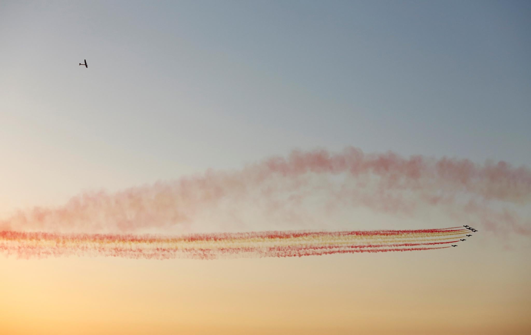 The solar-powered plane Solar Impulse 2 (top L), piloted by Swiss aviator Bertrand Piccard, flies over Spanish air force aerobatic team Patrulla Aguila before landing at San Pablo airport in Seville, southern Spain June 23, 2016