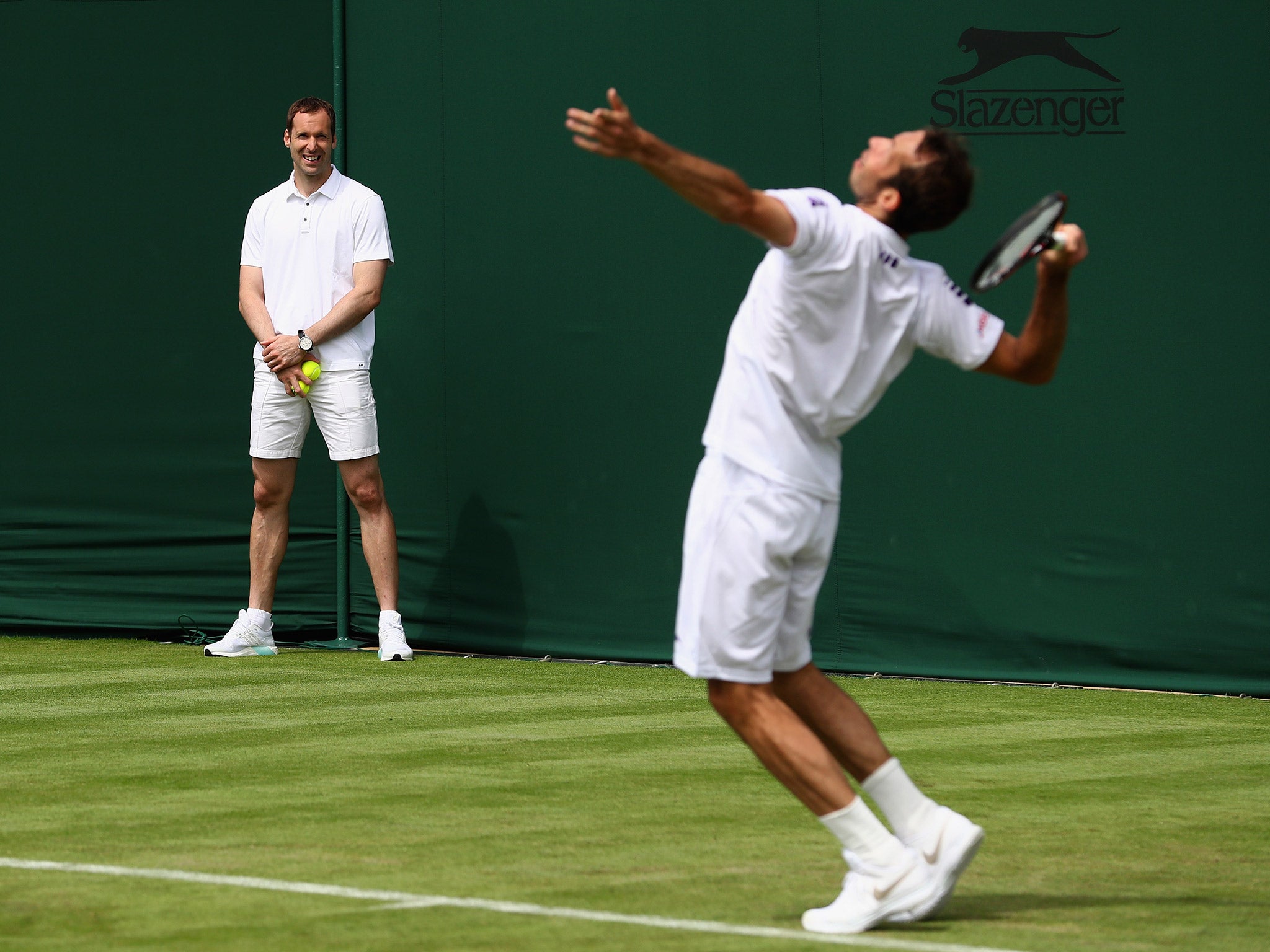 Petr Cech acts as a ball boy while Radek Stepanek and Lukas Rosol train at Wimbledon