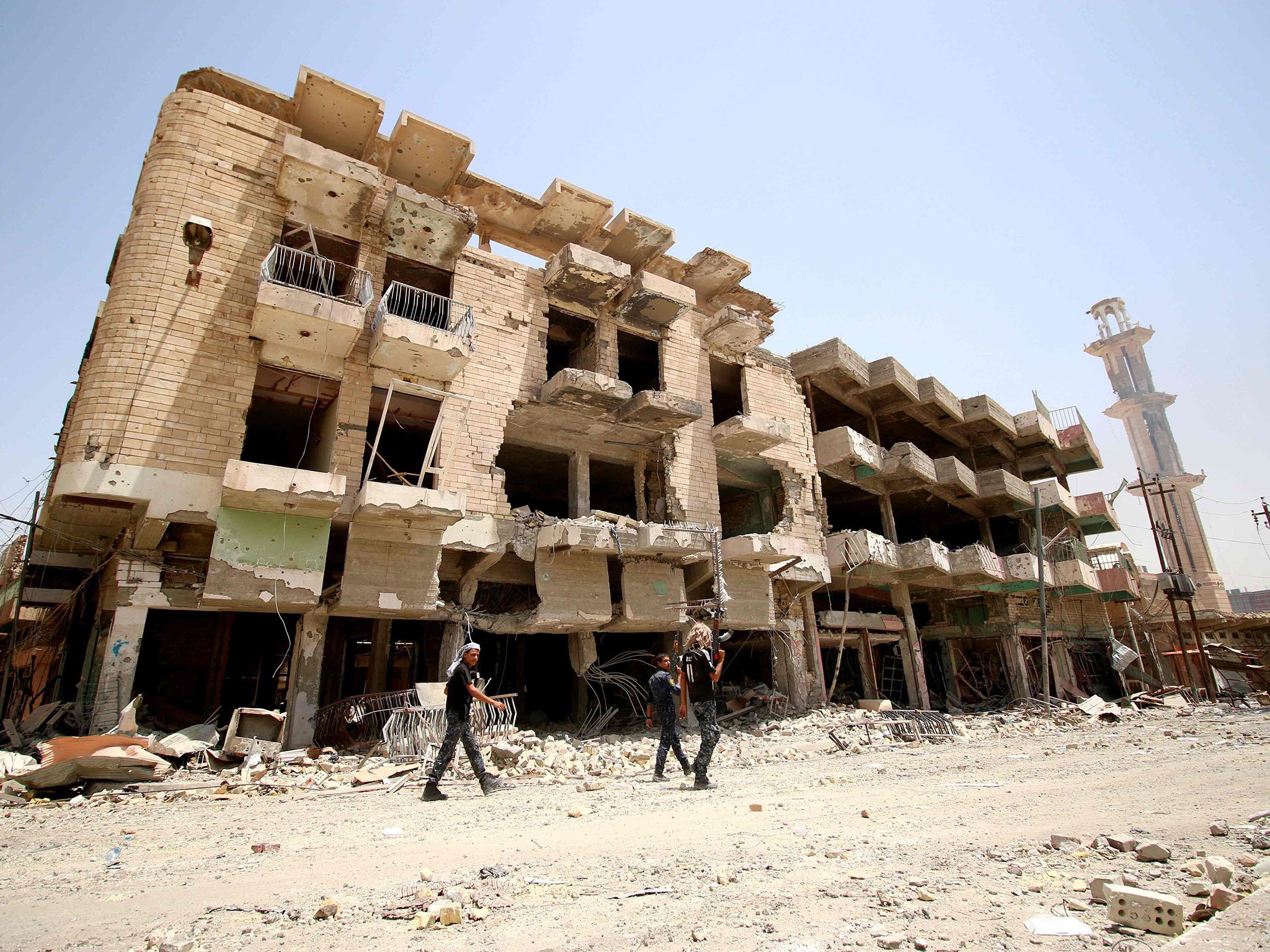 Members of Iraqi government forces patrol a street on June 27, 2016 in western Fallujah