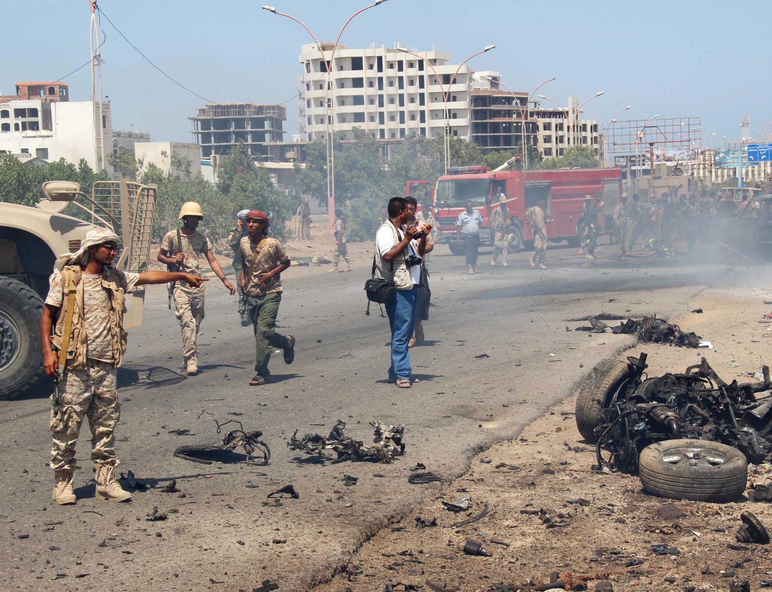 Soldiers gather at the site of a car bomb attack in a central square in the port city of Aden, Yemen, in May