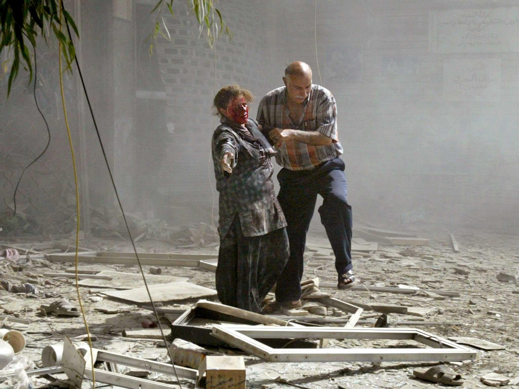 A wounded Iraqi woman is helped after several bomb attacks in central Baghdad in 2006