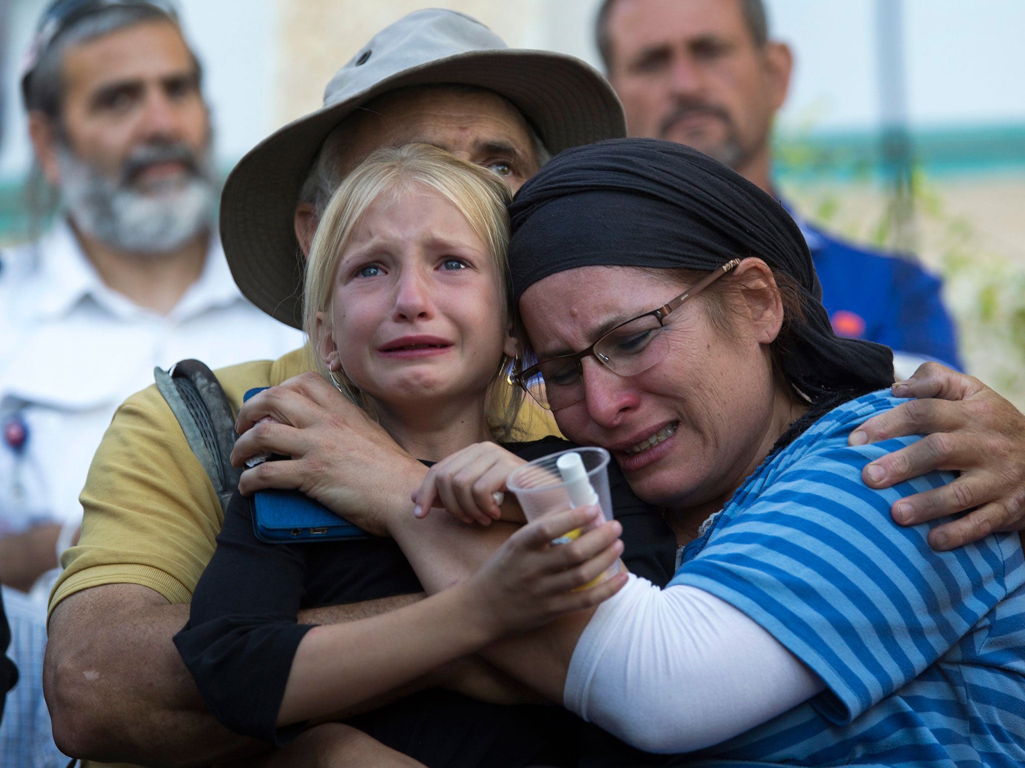 Hillel's mother, sister and father mourning at her funeral