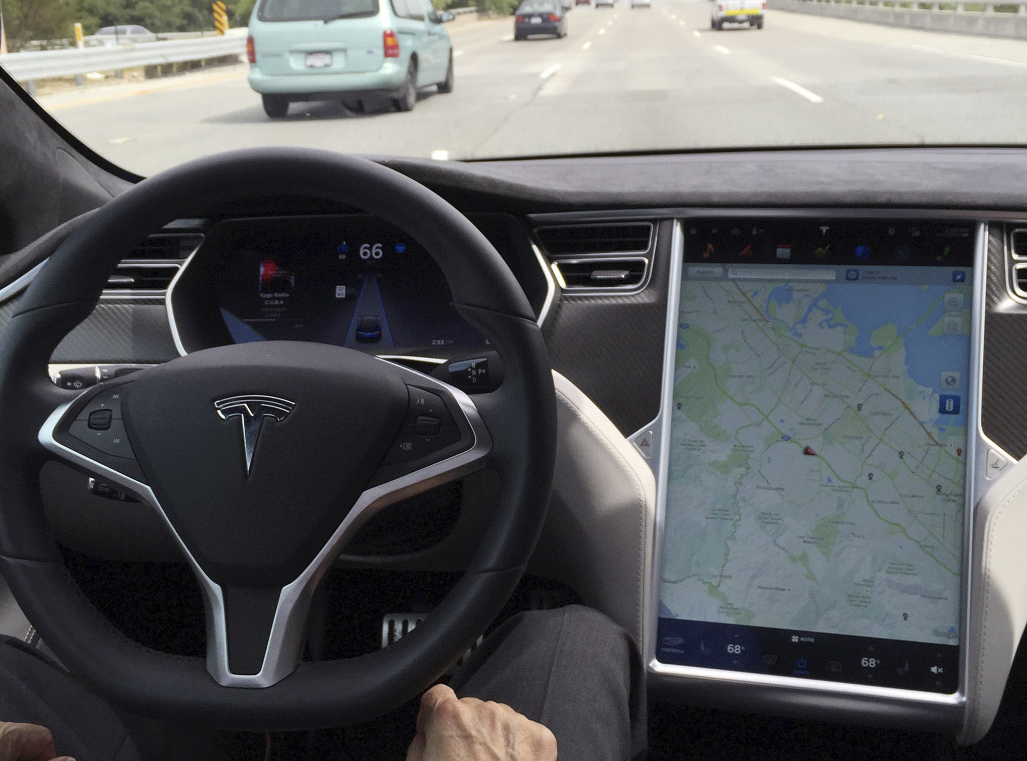 The interior of a Tesla Model S is shown in autopilot mode