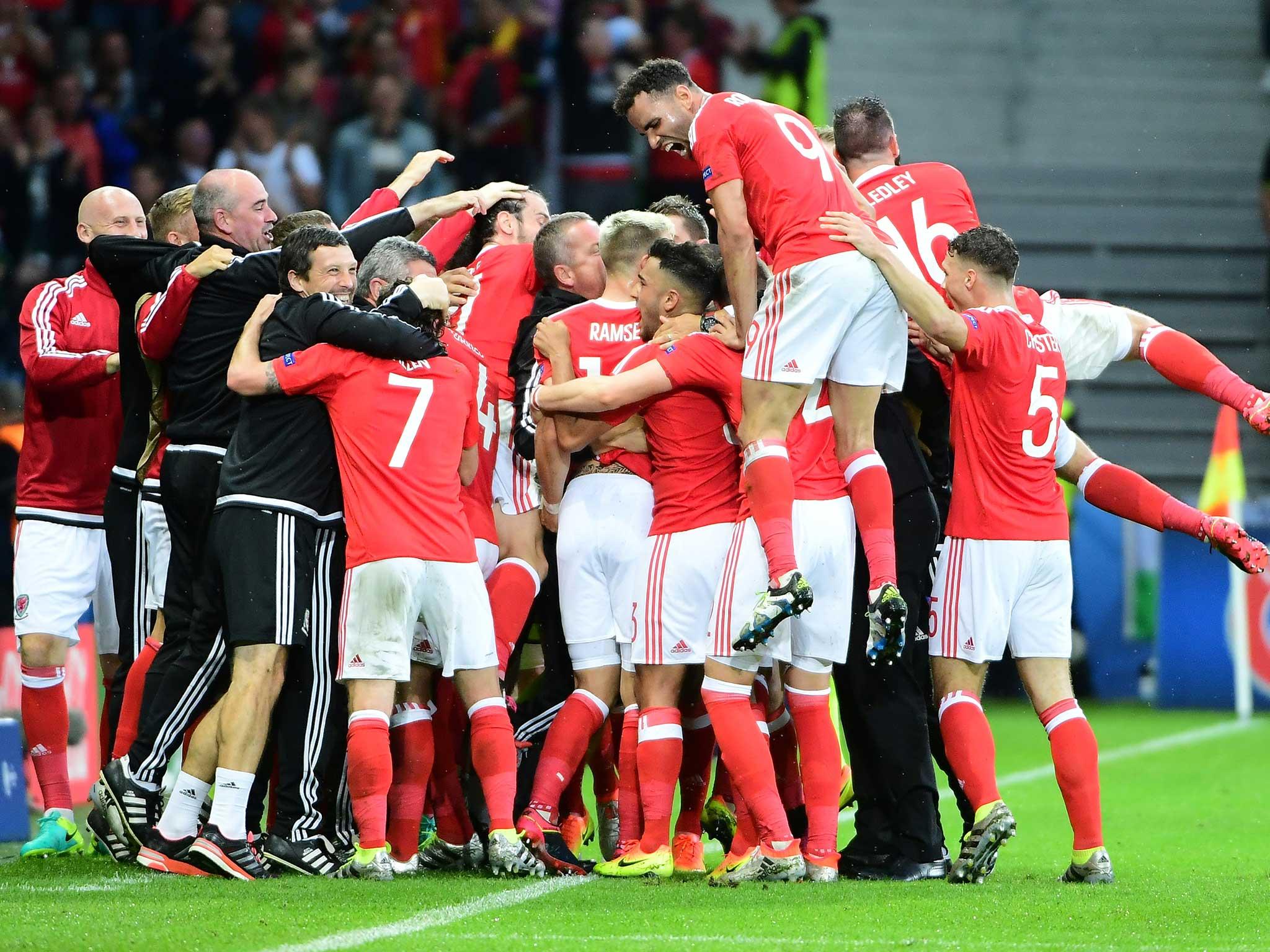 The Wales team mob Ashley Williams after his opener