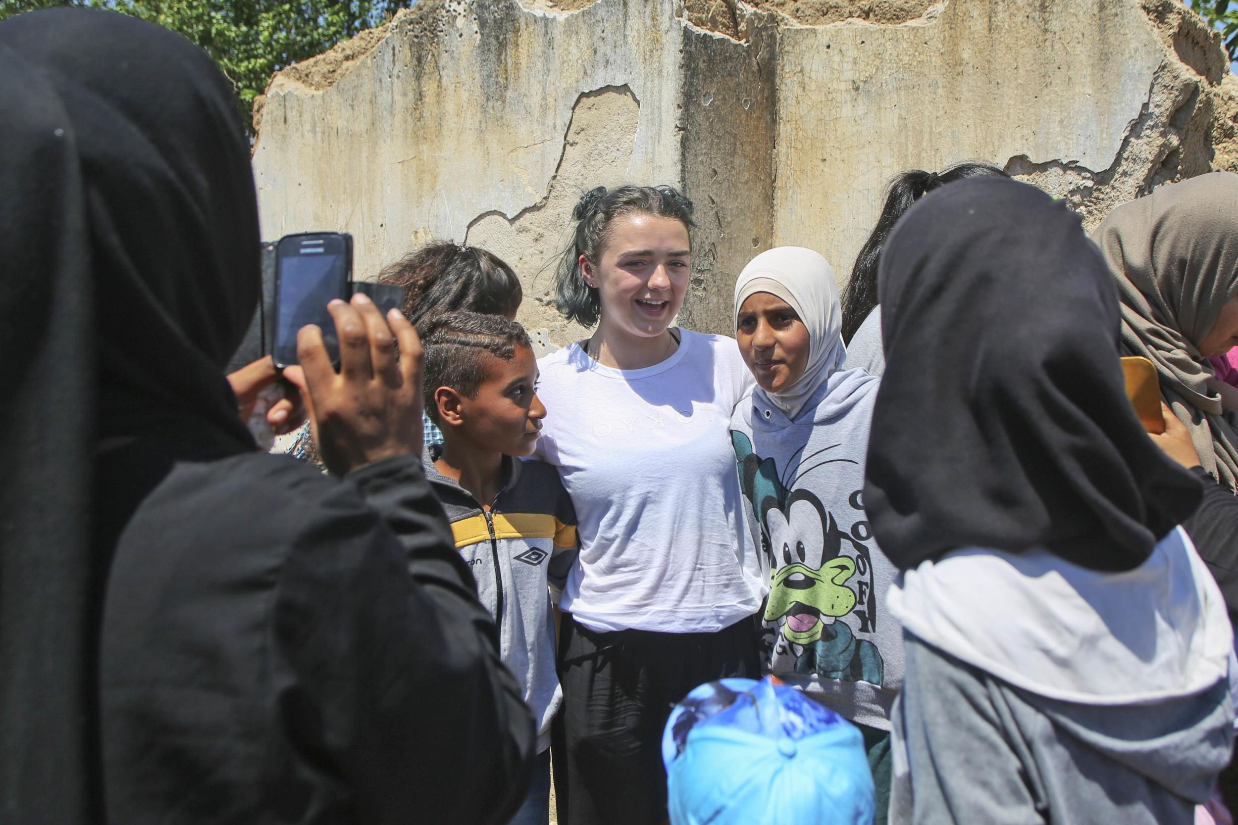 Maisie Williams, centre, poses for a photo with refugee girls in the Cherso refugee camp, northern Greece