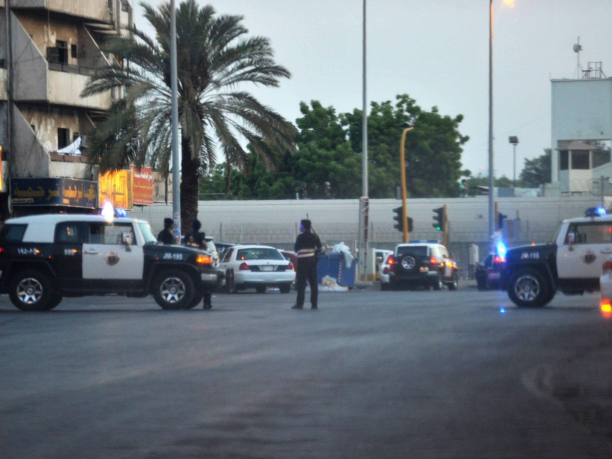 Saudi policemen stand guard at the site where a suicide bomber blew himself up near the American consulate in the Red Sea city of Jeddah