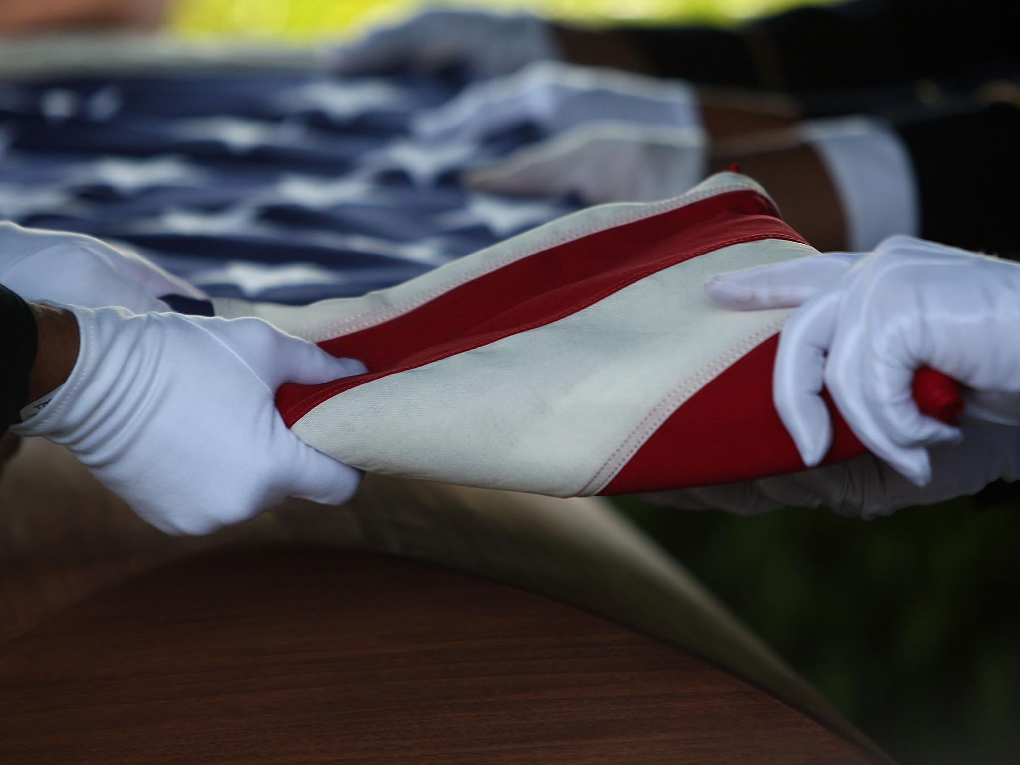 &#13;
A military honor guard folds the the American Flag a top the casket of US Army Specialist Daniel Agami of the 1st Infantry Division as he is laid to rest at Star of David Memorial Gardens June 26, 2007 in North Lauderdale, Florida &#13;