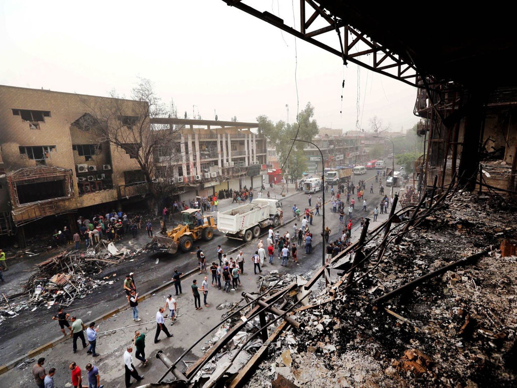 Iraqi security forces and civilians gather at the site after a car bomb hit Karada, a busy shopping district in the center of Baghdad, Iraq