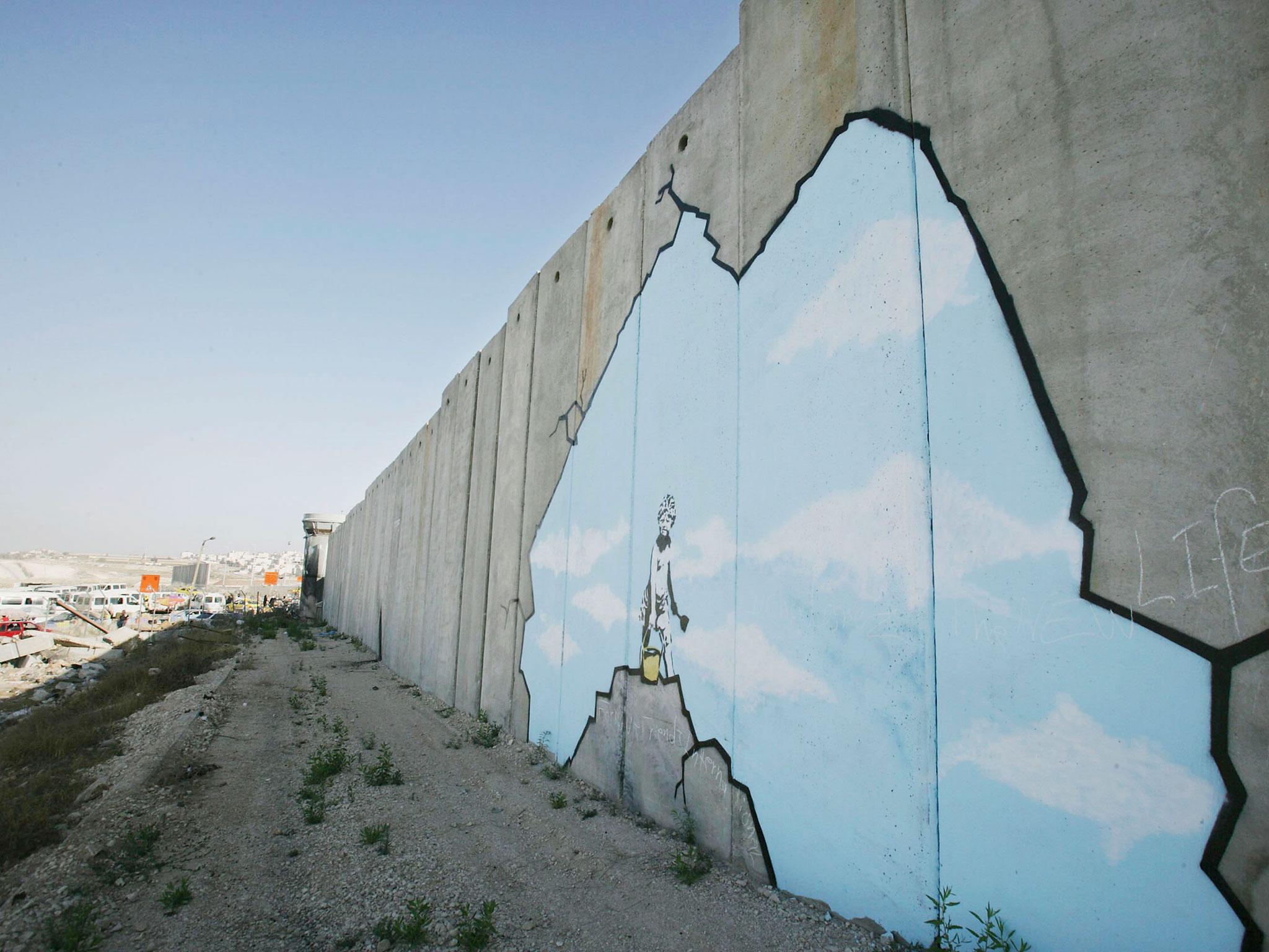 Graffiti titled 'Art Attack' made by the British guerrilla graffiti artist Banksy is seen on Israel's highly controversial West Bank barrier in Ramallah