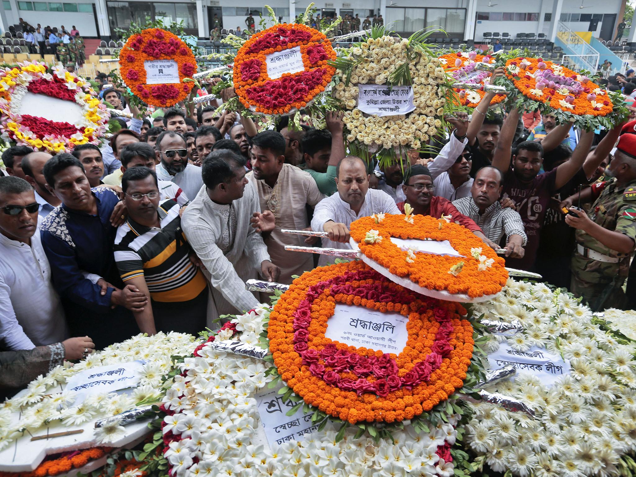 Local residents pay their respects to the victims of the attack at the Holey Artisan Bakery at a stadium in Dhaka, Bangladesh