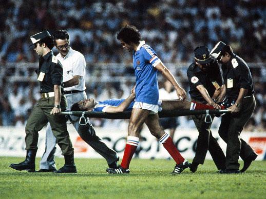 Patrick Battiston is taken from the field on a stretcher after the challenge from Toni Schumacher in 1982 (Getty)