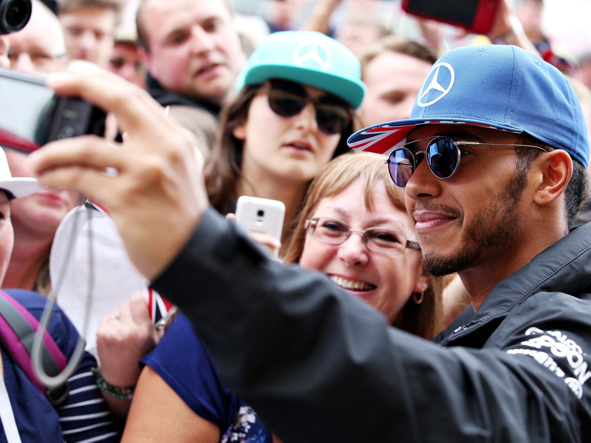 Lewis Hamilton takes a selfie with a fan ahead of the British Grand Prix weekend