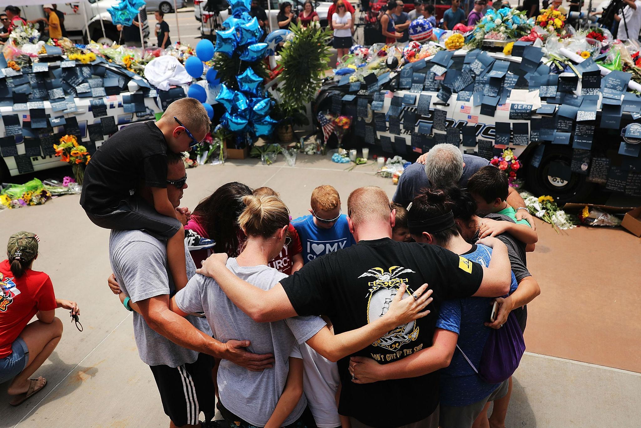 Mourners continued to gather at a makeshift memorial outside Dallas Police headquarters on Saturday