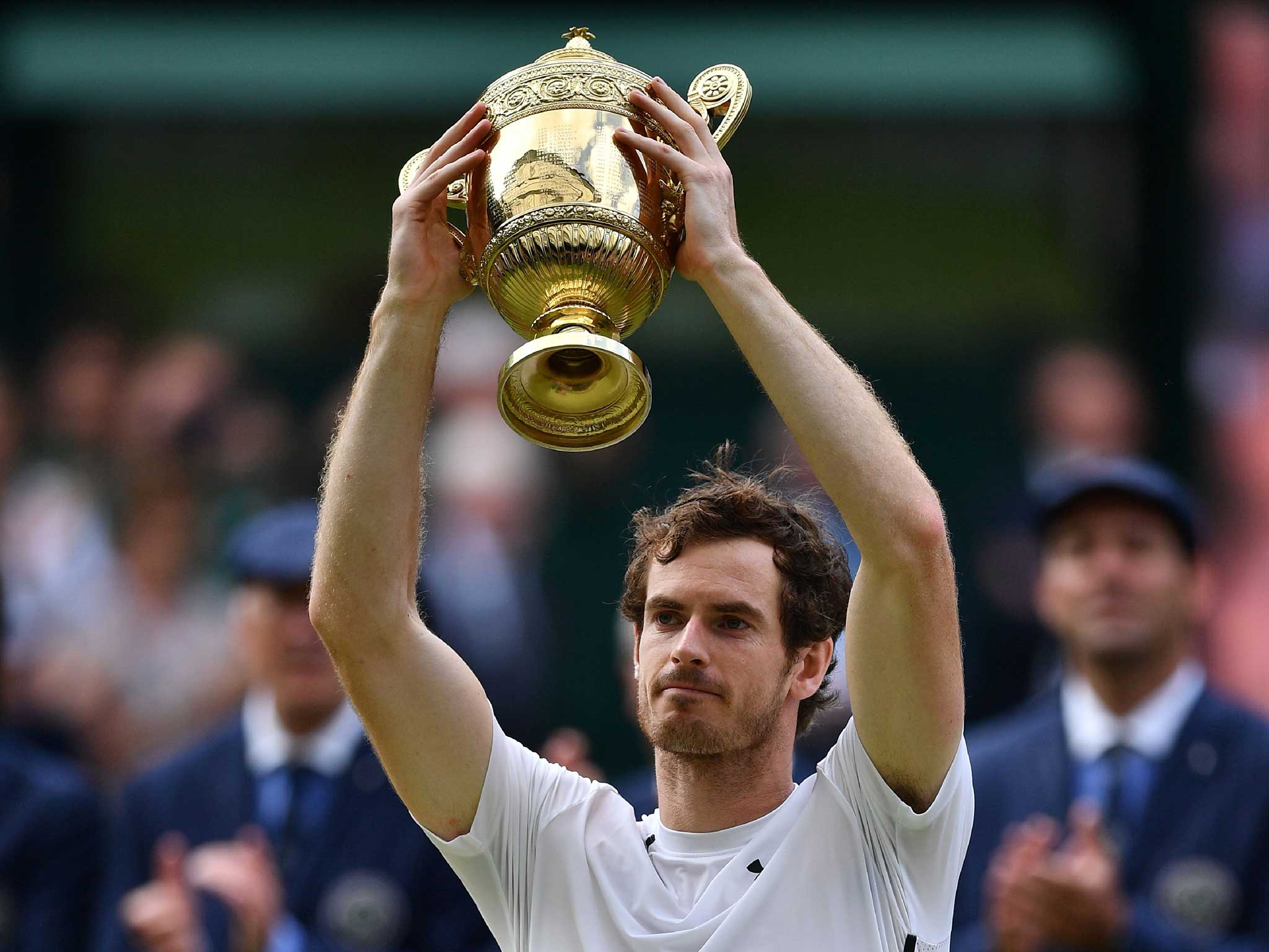 Murray hoists the Wimbledon trophy above his head after defeating Raonic