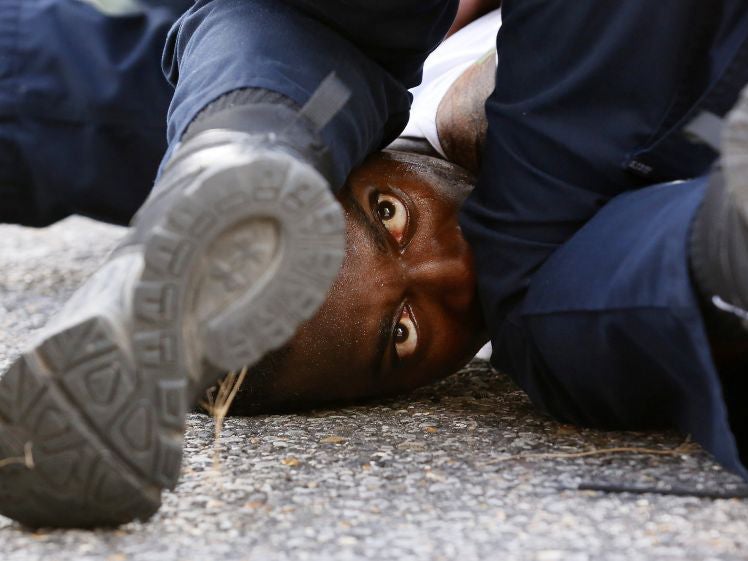 A man protesting the shooting death of Alton Sterling is detained by law enforcement near the headquarters of the Baton Rouge Police Department (Jonathon Bachman/ Reuters )