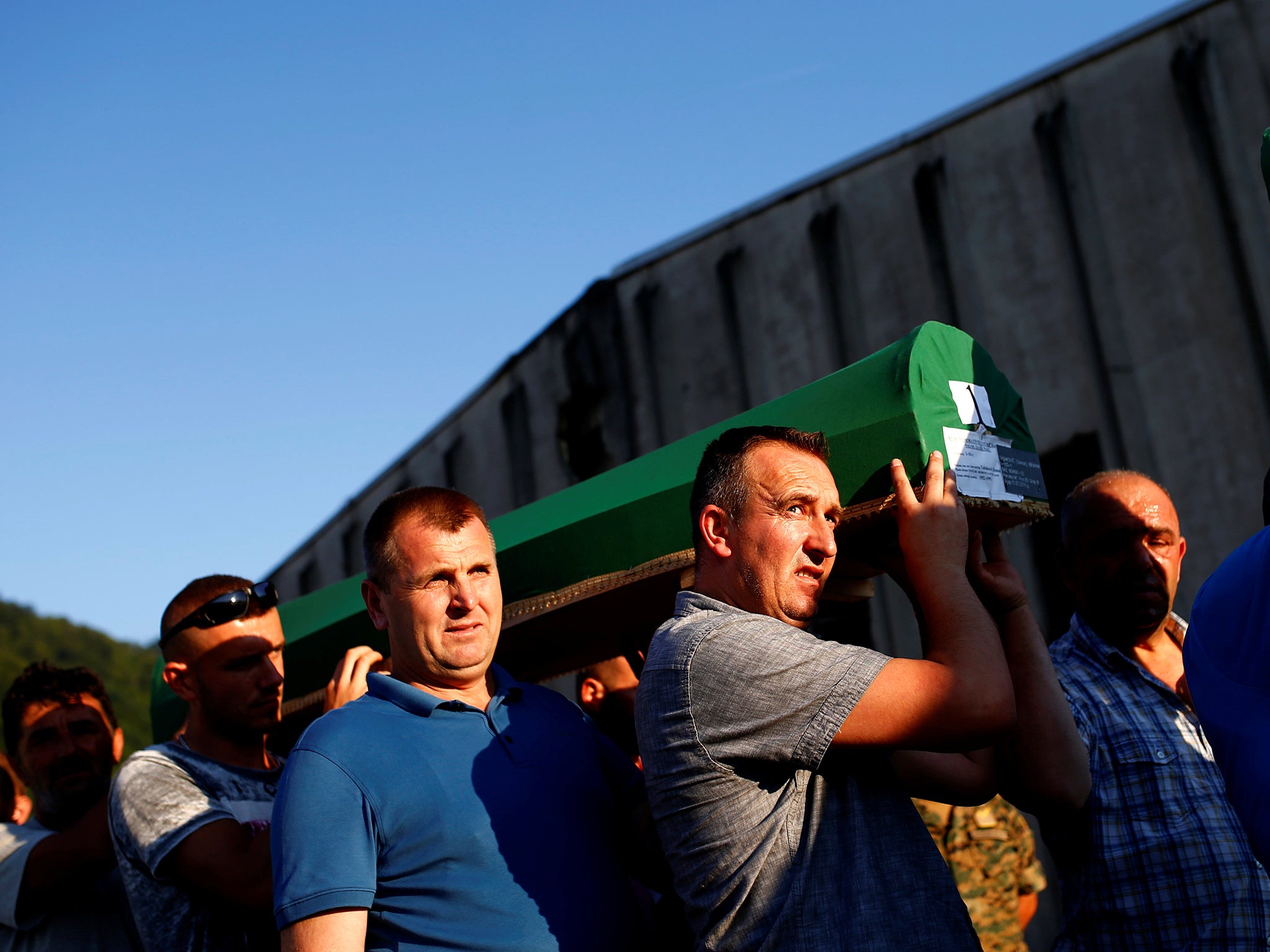 Muslim men carry coffins of their relatives, newly-identified victims of the 1995 Srebrenica massacre