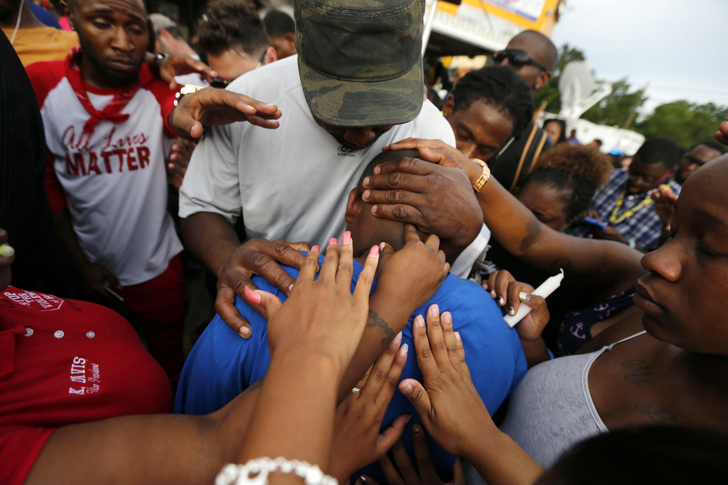 Cameron, 15, is comforted by relatives and friends